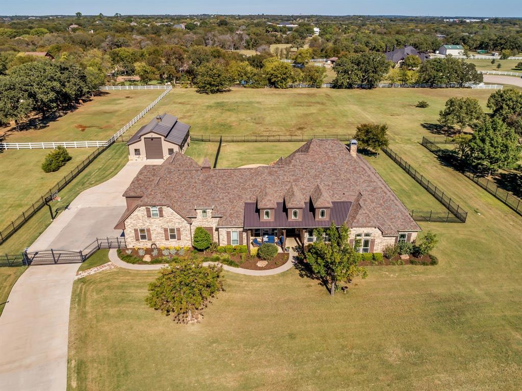 A home designed to be lived in, loved, and shared. This stunning Saddlebrook Estates home was completely remodeled in 2022 and is ready for you to move in. Open the door to this inviting residence that offers warm, open living spaces and flexible upstairs area ideal for a game room, studio, or guest retreat. The chef’s kitchen features a NEW Sub-Zero refrigerator, GE Monogram 48” 6 burner range with griddle, Bosch dishwasher , Reverse-osmosis water system, and a KitchenAid ice maker which uses the RO system. Hand-scraped wood floors, marble flooring is in the kitchen, bathrooms and laundry room. All countertops are leathered quartzite. The primary bedroom, primary bath, living room and kitchen have Hunter Douglas remote controlled room darkening shades and the secondary bedrooms have Pottery Barn custom room darkening drapes which will convey. The primary bedroom offers a large walk in closet that connects with the laundry room.  Other updates include Champion windows, Class 4 roof shingles with ridge vents,  HVAC, two tankless water heaters, and LED lighting throughout. Enjoy backyard living with a 9 foot deep, saltwater diving pool, catch-a-kid net, two covered seating areas, one with a masonry fireplace, and the other with an outdoor kitchen. Sonos speakers are wired for both inside and outside listening of your favorite music. Pet-friendly wrought-iron fencing has been included to keep your animals safe. Full irrigation is included in the front acre of the property while the aerobic sprinklers are located in the back acre. The additional 1,200 sq ft shop is climate-controlled with a bathroom as well as washer and dryer hookups, and epoxy flooring. This space is perfect for an extra vehicle or boat parking, work-out area, storage, or hang out space. This is a home where luxury feels comfortable and spaces feel intentional. Come see for yourself the love and care that has been put into every inch of this home.