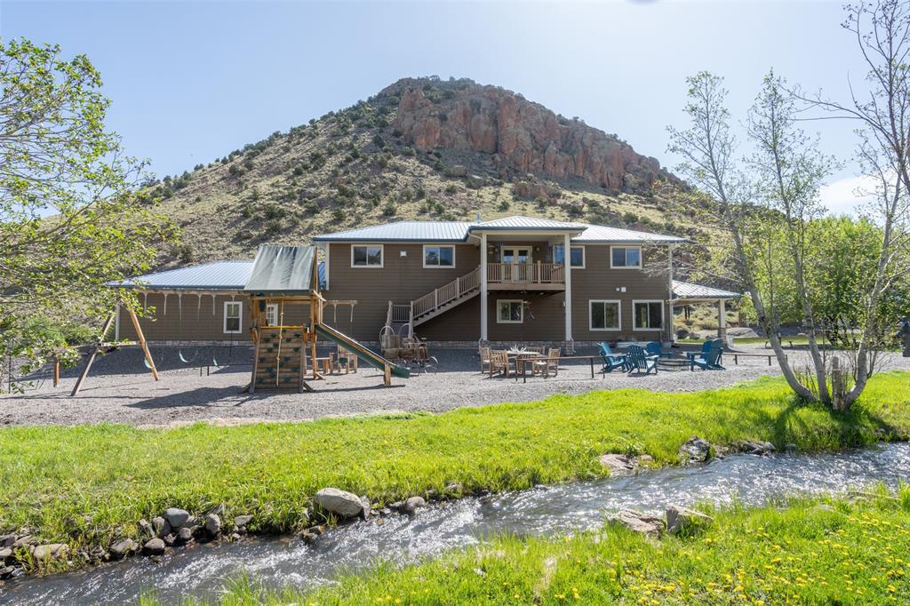 7R Ranch features a stunning custom home and a heated shop situated on 73 acres that border more than 220,000 acres of public land. San Francisco Creek runs year-round through the property, offering over four-tenths of a mile of scenic creek frontage. Wildlife including deer, elk, and wild turkey frequently pass through the ranch at different times of the year.Located just four miles south of Del Norte, the property is also within an easy 38-mile drive to Wolf Creek Ski Area. The elevation ranges from 8,200 feet at the valley floor to 8,760 feet at the ridge on the eastern side.
With annual property taxes of only $5,054 and modest road maintenance dues of $175, this ranch boasts exceptionally low holding costs. Gardening enthusiasts will appreciate the raised beds and two greenhouses, offering ample space to grow vegetables, flowers, or herbs.
The 8,000-square-foot custom home, built and maintained by its original owner, showcases pride of ownership throughout. Previously operated as a bed and breakfast, the main level features six en-suite bedrooms—each with walk-in closets, individual thermostats for the in-floor radiant heating system (divided into 12 zones), and French doors that open onto a wraparound porch.
A gourmet chef’s kitchen includes two oversized islands, double ovens, a six-burner cooktop with a pot filler, two sinks, two dishwashers, and two microwaves—perfect for entertaining or large family gatherings. The luxurious primary suite offers French doors that open toward the creek, large windows that fill the space with natural light, and a double-sided fireplace that continues into a spacious bathroom.
Upstairs, you'll find a full bathroom, a massive office or den with custom cabinetry, and a large hobby room with a covered balcony overlooking the creek. This space was previously used as a professional quilting and sewing room.