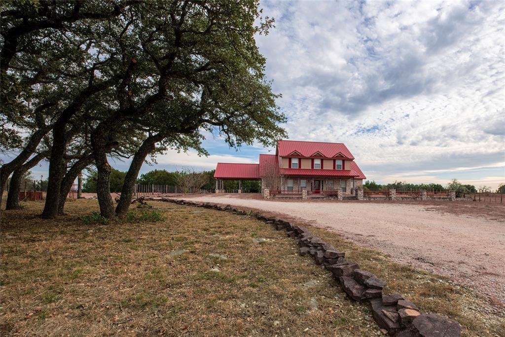 The White Ranch offers the best of country living with lovely drive up appeal to a 2,304 sq. ft. (per Erath CAD) custom ranch home featuring 4 bedrooms, 2.5 baths, wood floors, and an open-concept design. The primary suite is downstairs, with three bedrooms and a Jack & Jill bath upstairs. Enjoy a custom patio with built-in smoker and pit and covered area. The ranch has slightly rolling topography. The land is a combination of light to moderate wooded native pasture, open cultivatable areas and areas of open coastal Bermudagrass and native-grass pasture. There are 3 modest earthen tanks and one electric water well for domestic and livestock water. Improvements include a 60’x40’ metal barn with power, concrete slab foundation. The attached barn area measures 45' x 60', metal pole frame with metal roof and an attached shed area of 30'x40'. Fencing is barbed wire with cedar stave fencing at the entrance. There are 3 gated entrances. Wildlife include whitetail deer, wild turkey, dove, and occasional ducks on the stock tanks. Erath County enjoys a diverse bird population, The ranch is 20 miles south of Stephenville, 65 miles southwest of Fort Worth, 90 miles southeast of Abilene and 175 miles north of Austin.  Photos coming soon.