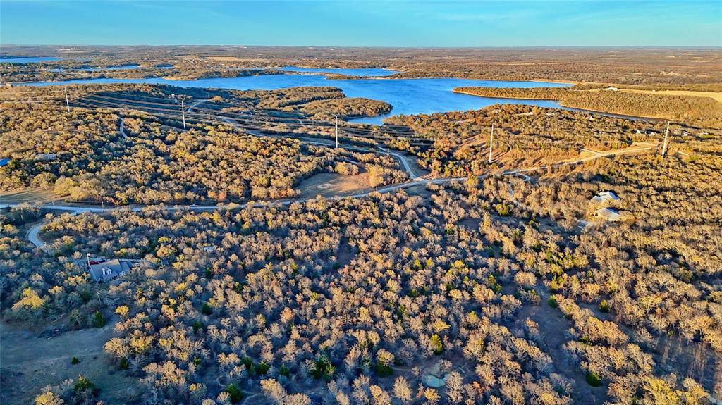 Welcome to Lot 404 in the coveted Silver Lakes Ranch community — a stunning 5-acre retreat tucked along the quiet, winding stretch of 1943 Lakeridge Road in Sunset, Texas. Spanning two parcels, this property offers a rare blend of seclusion, natural elevation, and dense, mature trees that create a landscape full of depth, privacy, and beauty.
As you explore the rolling terrain, you’ll notice sweeping hilltop views peeking through the hardwoods, perfect for envisioning a future homesite that captures both sunrise and sunset. Whether you dream of a full-time residence, a weekend hideaway, or an investment for the future, this land provides the ideal canvas.
Silver Lakes Ranch is steeped in unique local history — once the site of a beloved Boy Scout ranch where generations learned to hike, explore, and appreciate the land. Today, that spirit of outdoor adventure has been thoughtfully preserved in a community designed for those who crave wide-open space paired with exceptional amenities. Residents enjoy access to two private lakes, a community pool, RV and boat storage, a fitness center, a clubhouse, shaded picnic areas overlooking Amon Carter Lake, and miles of scenic trails ideal for riding or roaming. All of this comes with impressively low $350 per year HOA dues.
The neighborhood’s story lives on in its spacious tracts, abundant wildlife, and the peaceful natural character that remains untouched by time. Lot 404 embodies all of this charm — a scenic, wooded haven that feels worlds away while still being an easy drive from Bowie, Decatur, and the DFW metroplex.
If you’re seeking land that offers both beauty and possibility, this hillside gem in Silver Lakes Ranch is ready to welcome your vision.