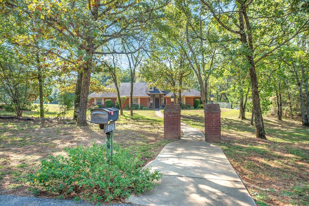 Enjoy the peace and quiet this wooded 2 acre property offers in Lindale ISD just under 5 miles from the elementary schools. Spacious 4 bedroom with split floorplan. Guest bedrooms adjoined by jack-n-jill bath. Large master suite with inset ceiling, 3 closets and separate sink vanity areas. Large 20x18 living room, spacious dining area and island kitchen with 2 pantries. Garage has been converted into a nice craft room or bonus room and partial storage space. This bonus space would be great as a homeschooling classroom, music room or office. Outside, enjoy the covered patio and 14x20 shop.