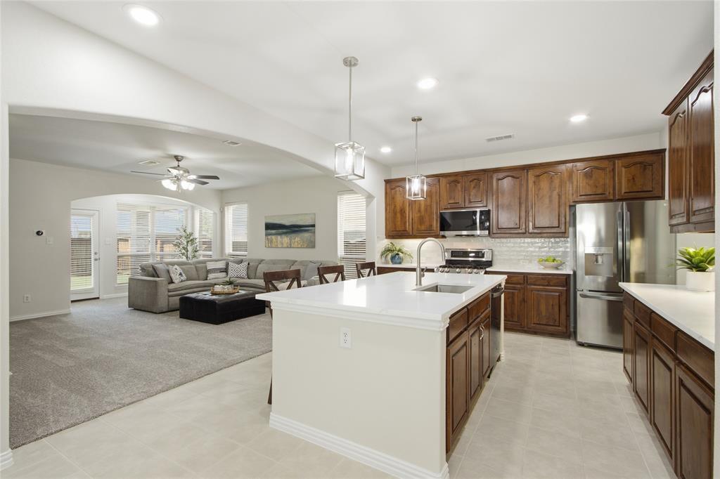 BEAUTIFUL, MOVE-IN READY, 4 BEDROOM HOME IN THE AWARD-WINNING COMMUNITY OF LANTANA! Fresh, clean, and meticulously maintained, this home features extensive recent updates including fresh interior paint, new carpet, quartz kitchen countertops, a stylish new backsplash, updated light fixtures, newly added backyard sod, and freshly epoxied garage floors. The roof and gutters were replaced just two years ago, providing added peace of mind.. The fantastic floor plan offers a private primary suite on the main floor, while upstairs you'll find three oversized secondary bedrooms—each with a walk-in closet—plus a large game room, media room, and giant storage closet. Incredible storage space throughout! The light-filled family room features built-in bookcases and a fireplace, creating the perfect gathering space. Outside, enjoy a covered patio and grassy backyard with plenty of room to play, entertain, or simply relax. Front yard maintenance is included through the HOA for easy living. Experience the unmatched Lantana lifestyle with resort-style pools, fitness centers, tennis and pickleball courts, golf, playgrounds, miles of hike and bike trails, community events, highly rated schools, and a true sense of community. Conveniently located near shopping, dining, and major highways, with easy access to Lake Lewisville, Grapevine Lake, several major North Texas universities, DFW Airport, and both downtown Fort Worth and Dallas, making it easy to enjoy everything the DFW Metroplex has to offer.