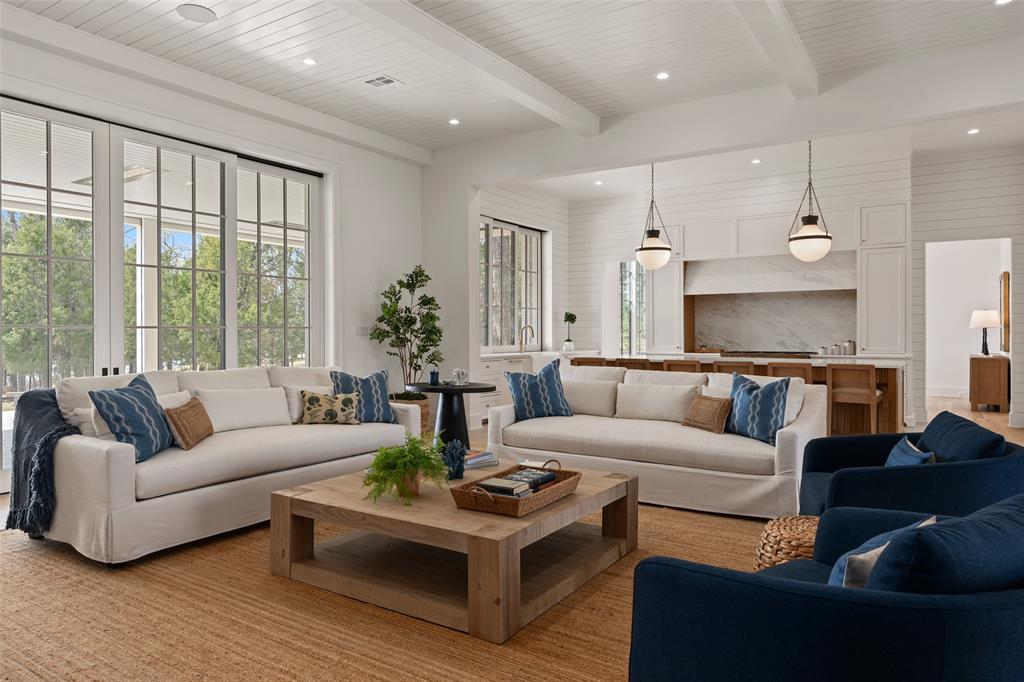 Positioned on Henderson Bay, set beneath a beautiful tree canopy and adjacent to a creek, this thoughtfully designed 6-bedroom, 6.5-bath lake front home blends traditional and contemporary architecture, creating a warm, welcoming lake retreat with quality craftsmanship, elevated materials, and custom design. Home comes FURNISHED!! Step through the iron entry door and note the exterior stone that transitions into the interior wall. A light-filled family room with a stone fireplace and a kitchen featuring custom cabinetry, designer lighting, and gourmet appliances welcome you and your guests. The dining room includes a wet bar and wall-to-wall windows framing creek views. Outdoor entertaining continues on the large rear patio, which opens to the family room through fully receding doors and to the kitchen through a collapsible bar window, and includes retractable screens and heaters for year-round use. A creekside patio off the dining room features a built-in grill and additional seating, perfect for gathering and dining outdoors. Two primary suites are located on the first floor: a main suite with lake views and a second suite with private access to the creekside patio. Upstairs includes a custom en-suite bunk room, two en-suite guest rooms with lake views, and a bright hallway with bench seating. A flex space for a second living area or office sits near the upper creekside patio. An impressive 900 sq ft bonus room with a full bath can serve as a game room, bunk space, golf simulator, or additional primary suite, offering exceptional versatility. The landscaped lot can accommodate a pool and offers space to further customize outdoor living. The home is pre-registered for membership in the Old Mine Club, featuring The Canary, an 18-hole championship course by Beau Welling (expected 2027). As part of Long Cove, residents enjoy resort-style amenities including tennis, pickle ball, trails, pools, 84k sf putting green and a vibrant lakeside setting.