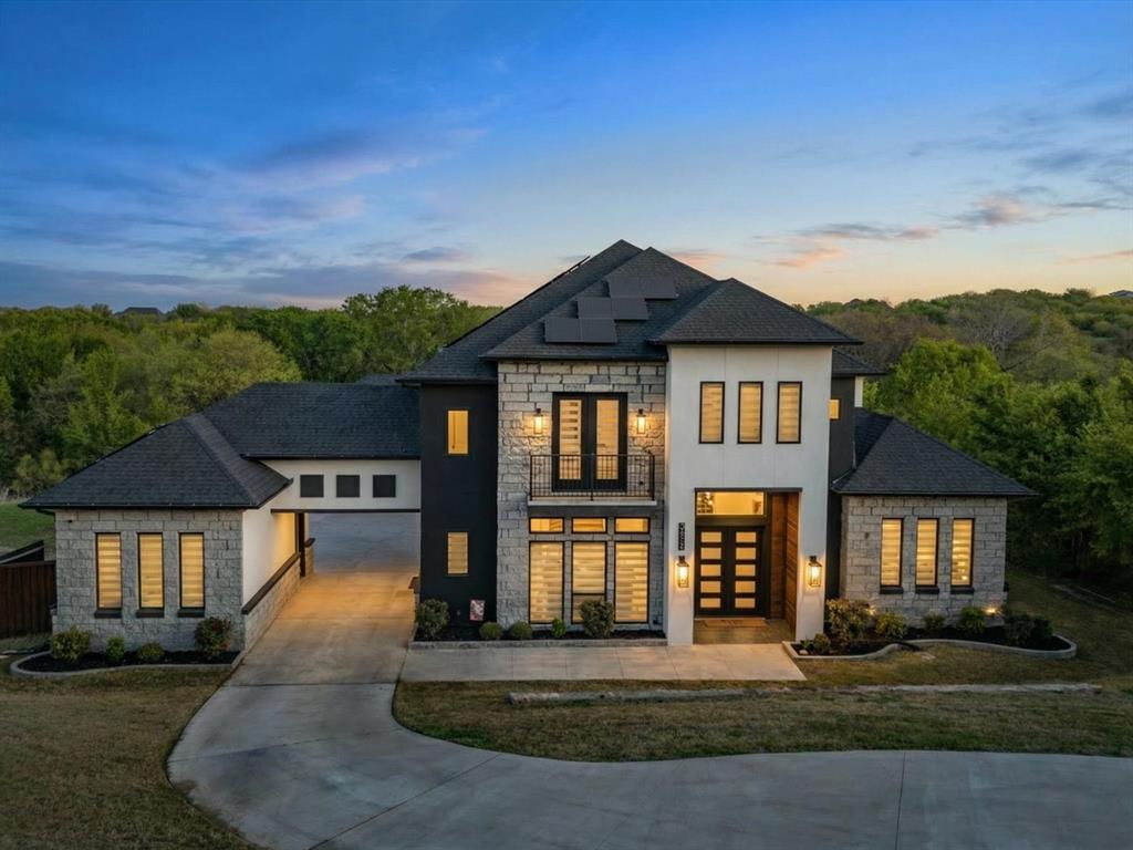 Stunning custom modern contemporary home in the immaculate Lake Ridge community, thoughtfully designed with dramatic architecture, refined finishes, and a scenic backdrop of mature trees and green space. The grand foyer makes an immediate impression with soaring ceilings and floor-to-ceiling windows that flood the formal living and dining spaces with natural light. The open-concept design continues into an expansive main living area with oversized sliding doors and seamless indoor-outdoor flow for entertaining. A private study offers flexibility for working from home, while the dedicated wine room and stylish wet bar add to the home’s upscale entertaining appeal.

The gourmet kitchen is a standout, featuring quartz countertops, top-tier stainless steel appliances, extensive custom cabinetry, designer lighting, and a striking oversized island. The primary suite is a true retreat with peaceful tree-lined views, generous proportions, and direct access to a private balcony ideal for morning coffee or unwinding in the evening. The spa-inspired bath offers a freestanding tub, oversized remodeled shower, dual vanities, and a custom walk-in closet. A second primary suite on the lower level adds versatility for guests or multigenerational living, while the three-car porte-cochere garage enhances both function and curb appeal. Solar panels plus a Generac whole-home generator provide meaningful energy and backup-power benefits. 

Set near Tangle Ridge Golf Club, this home also enjoys convenient access to some of Cedar Hill’s best outdoor attractions and entertainment. Nearby destinations include Joe Pool Lake and Cedar Hill State Park for boating, fishing, kayaking, trails, and camping, along with Dogwood Canyon Audubon Center and Cedar Ridge Preserve for hiking, nature exploration, and scenic overlooks. This exceptional property blends luxury design, thoughtful livability, and a sought-after Cedar Hill location near golf, lakes, trails, shopping, and dining.