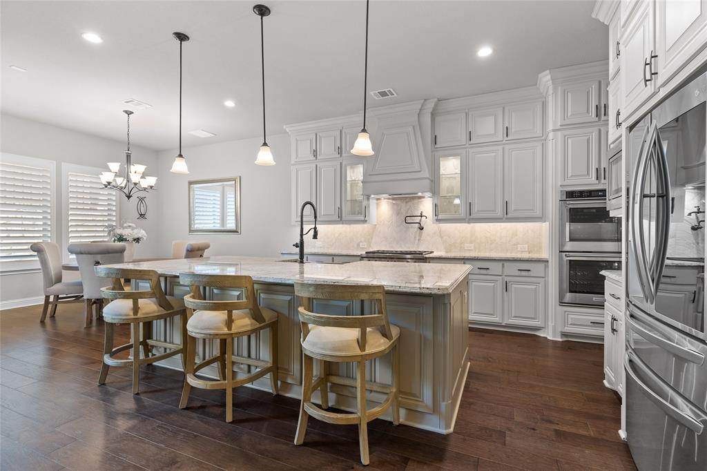 Just listed in the exclusive & gated Paradiso Valle of Stonebridge Ranch! Looking for exceptional finishes in a better than new 2021 built home with all the extras? From the moment you step through the handsome iron door into the two-story foyer, you’re greeted by a gorgeous wood & iron staircase and a 20ft vaulted, open-concept great room with a massive floor-to-ceiling stone fireplace. An equal showstopper is the superb island kitchen, featuring a gorgeous chevron-style marble backsplash, pot filler, glass-front & double-stacked cabinets to the ceiling, high-level granite, pendant lighting, double convection ovens, a Wolf 6-burner cooktop, farmhouse sink & a walk in pantry room. Hickory wood floors in an espresso finish grace the main areas downstairs. Retreat to the first floor primary suite, a true sanctuary boasting tray ceilings, a spa-like bath with a free standing soaking tub, and an oversized walk-in closet. Also on the main level: a guest or MIL suite with step in shower, a study or office with glass doors, a flex or entertainment room & under stair wine nook. Upstairs, both a game room loft and a media with 5.1 surround-projector & screen to convey, anchor the third & fourth bedrooms, providing a perfect secondary living zone. ALL bedrooms have ensuite baths. ALL 5 wall mounted TV's convey. Entertain with ease on the patio with a built-in, never-used KitchenAid gas grill, dual-burner cooktop, & sink. In wall pest defense system. 138K in total options & upgrades. You will enjoy the benefits of a secure, boutique-style, smaller community, yet all the benefits of the Stonebridge Ranch amenities: Aquatic center, tennis, golf, pickleball, basketball, lakes & parks and trails. Zoned for top-rated McKinney schools, 5–10 minutes to HEB, Whole Foods Market, shops, dining & Adriatica Village. 12 min to downtown McKinney, 5 minto Baylor Scott and White Hospital, 15 min to the DNTollway, 19 min to the PGA District.