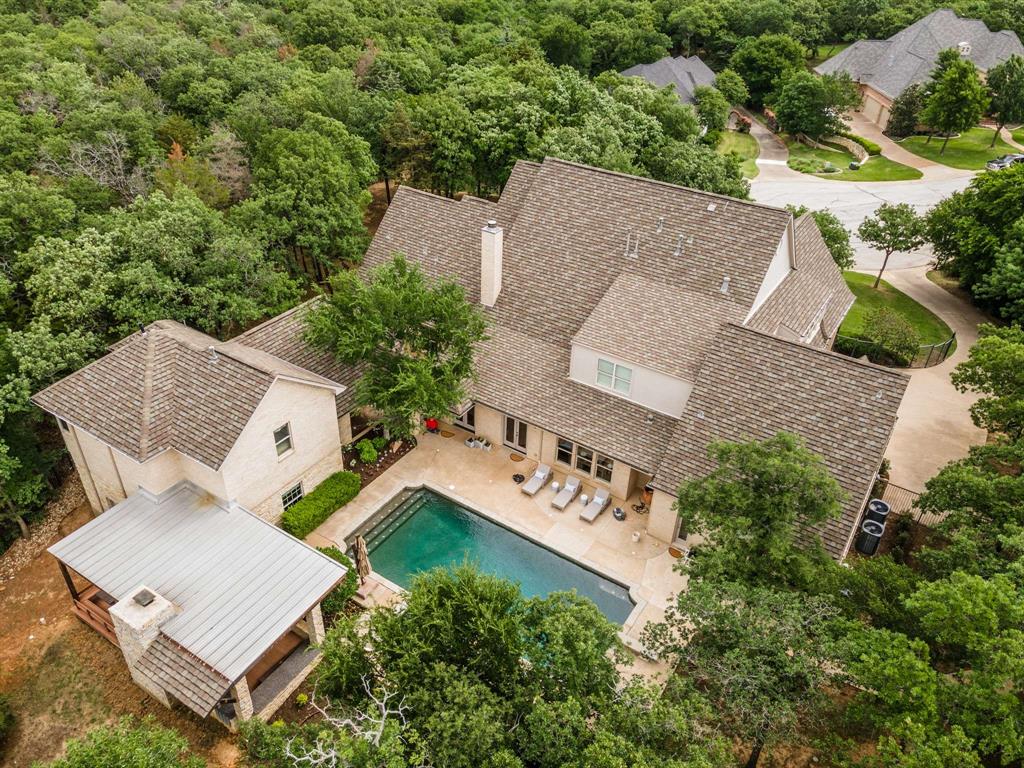 This exceptional estate offers a rare blend of luxury, space, and flexibility featuring a 5-bedroom main residence and a private guest house. The standout guest house spans 1,652 sq ft, complete with a large living area, full kitchen, bedroom, and bath—perfect for extended family, guests or entertaining. The main home includes a guest suite and primary bedroom on the first floor and three spacious upstairs bedrooms—all with ensuites—plus a game room and media room. Relax in the resort-style backyard featuring a sparkling pool and spa, outdoor living area all surrounded by lush landscaping. Nestled on a full acre in a quiet cul-de-sac and located within top-rated Carroll ISD, this home is just minutes from shopping, dining, and all the conveniences Southlake has to offer. This is more than a home—it’s a lifestyle.