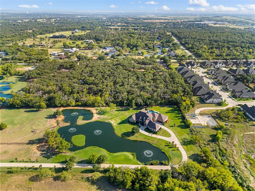 Experience luxury living at its finest in this beautifully renovated estate in the prestigious Frenchtown Manor Estates, located within the highly sought-after Argyle ISD. Set on over 4 acres, this 6-bedroom, 5.5 bath home offers an exceptional blend of elegance, comfort, and functionality.
Step inside to discover a fresh, modern renovation highlighting a thoughtful floorplan. The first floor features a spacious theatre room, perfect for movie nights or entertaining guests, 4 of the 6 bedrooms, and two staircases that add convenience & style.  The gourmet kitchen flows seamlessly into the dining room, which boasts a charming wine room for intimate gatherings. Retreat to the expansive primary suite, complete with a cozy sitting area and fireplace, creating a true sanctuary. Upstairs, a large gameroom, 2 bedrooms with their own private baths, and study area.
Enjoy the spacious laundry room that is a perfect drop zone or mud area. The 4-car garage has a generous storage room for all your needs.
Step outside to your private oasis: a sparkling pool with a cave waterfall, sunning area, and basketball goal, covered porch and outdoor cooking area—perfect for fun and relaxation. Picturesque ponds provide an impressive drive-up appeal to welcome you home every day.
