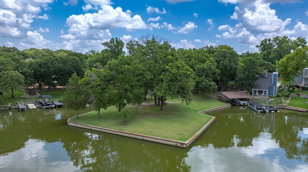 Escape to the Lakeside Living, with this rare, one-third of an acre lake lot on the beautiful Eagle Mountain Lake. This lake front property features several majestic oak trees that provide shade and character. You'll have excellent lake frontage on three sides of the property and your own private boat slip offering effortless access to the water. With its prime location and natural beauty, this lot combines tranquility, recreation and endless potential, whether for your next dream home, weekend retreat or multifamily project.