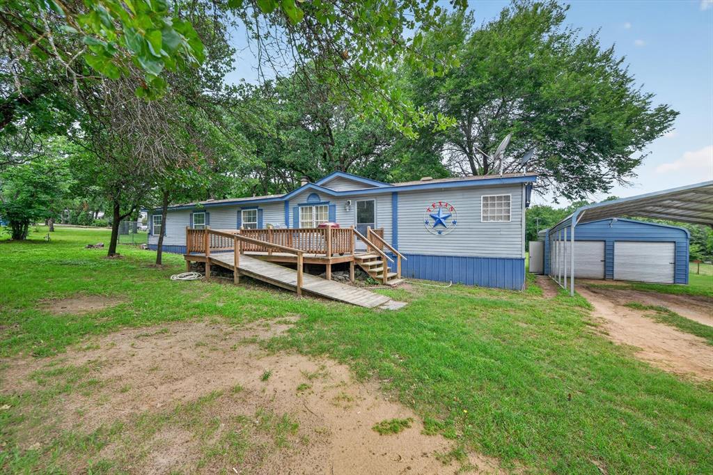 Welcome to your quiet country escape on 1.60 beautiful unrestricted acres in Boyd! Bring your animals and your dreams.  There are no deed restrictions and plenty of room to roam. Inside, the open-concept layout is perfect for effortless entertaining, with a dedicated office and abundant storage. Recent upgrades include new windows for comfort and efficiency. Outside, the property shines with an additional septic setup and extra electric service in the back, ideal for a future guest space, RV, or workshop. You’ll also love the 20x25 storage building for all your gear and the 12x20 portable garage for vehicles, equipment, or hobbies. The lot offers a great blend of open grassy areas and mature trees, giving you shade, privacy, and space to grow.  Country freedom, modern convenience, and room to expand.  This one has it all.  Ready to experience it in person? Schedule your private tour and make this country retreat yours!