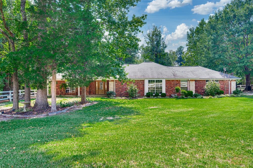 Welcome to the country life with this inviting, well maintained property south of historic Palestine in East Texas! Enter through the electric gate and follow the drive to this hidden 2 bedroom, 2.5 bath home on approximately 23 acres, where a tree-shaded front porch welcomes you inside. The open living, dining, and kitchen areas overlook the private, wooded backyard through a wall of windows spanning the rear of the home. The living area features a brick wood-burning fireplace with built-in cabinetry on each side, while the dining area offers additional built-ins with a serving bar. The spacious kitchen boasts an island with seating, extensive cabinetry, abundant counter space, and a breakfast area surrounded by windows. Both bedrooms include ensuite baths and walk-in closets. Tile floors throughout add ease of care. A two-car garage provides ample storage, and a large private back patio—part open, part covered—overlooks the fenced yard. Additional features include extra blown-in insulation, wide soffits, and an automatic full-house propane generator. The acreage is a haven for deer and wildlife with 2 springs and a creek running across it, plus complete perimeter and cross fencing with game fencing along the south and east sides. Pastures are improved with Bermuda and Bahia grasses. Here is a home for your horses at the barn that offers 6 stalls with concrete walkway, feed room, hay room with concrete floor, tack room, wash rack, sink(needs repair), and water with heater, while a pipe fence surrounds the paddock. A pole barn with electricity, water, wood floor, and exterior stalls adds more versatility. A small shop with bathroom, water heater, washer, and dryer—previously used for pet grooming—could serve as an office or hobby space. It is time for a new phase of life in the peaceful countryside, surrounded by nature.