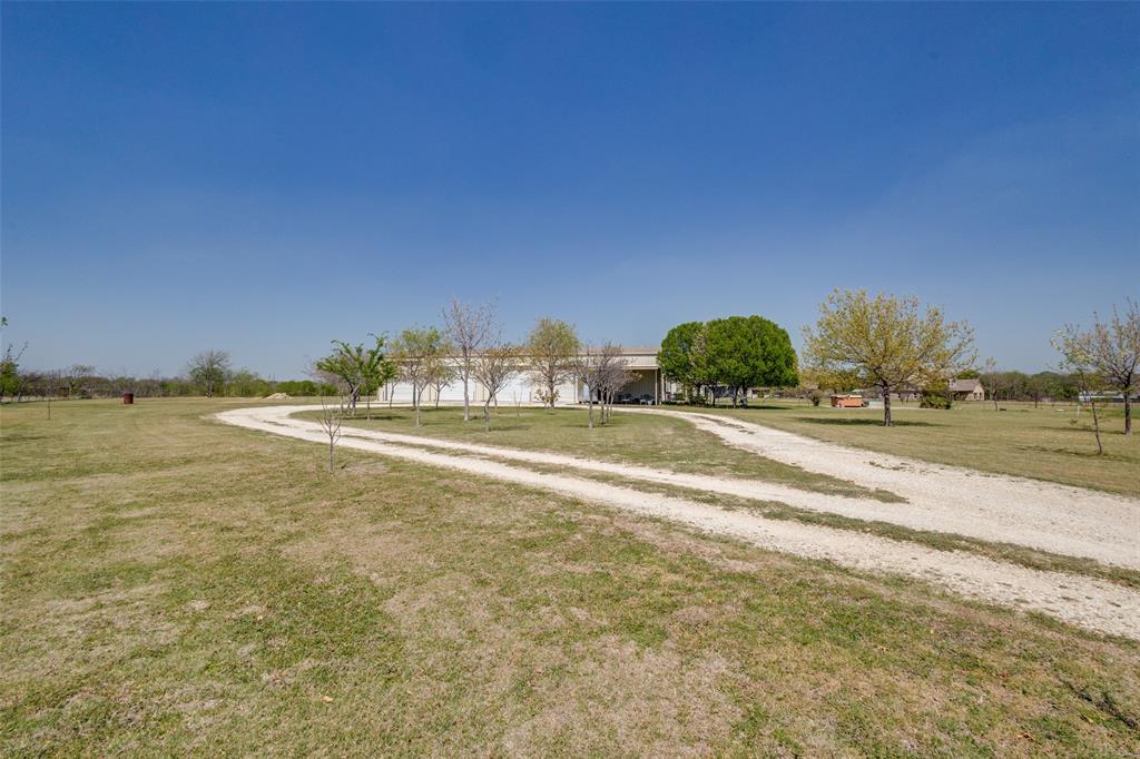 If you like lots of elbow room and a huge workshop, this property is for you! Barndominiums are very popular and this one is set on 10 sprawling acres just about 5 minutes north of charming downtown Krum. You're also less than 10 minutes from Denton with all the shopping, medical care, churches, schools and great restaurants. With 3600 square feet in the workshop side of the barndominium, there is room for EVERYTHING! This side has an RV hookup, is fully wired and completely insulated. The doors are rated to withstand up to 90 m.p.h. winds. Upstairs there is an open loft, a huge storage room that is 920 sq.ft. and another room that is often used as a bedroom. 
In the living area, the spacious kitchen flows into the family room that has lots of natural light. The master bedroom features a large walk in closet that is accessible from the second bedroom and the 3rd room is used as an office. There is plenty of insulation between the floors to reduce noise as an added feature. Now let's go outside and explore this wonderful property. There are fruit trees in abundance- peach, pear, apricot and pecan so you can enjoy the bounty from those and share with friends.You'll see 5 water storage tanks holding 3,000 gallons each; and the well is over 500 ft.deep. Exterior, night-friendly lights (pointed downward) surround the building and there are outlets in all the eaves as well. In addition, 7 of the 10 acres are ag exempt so your taxes are extremely low. This property has so many features that you really just have to see it, so go ahead and make that appointment to get it before somebody else does!