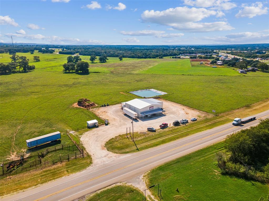 Hartness Ranch is a versatile 97± acre property located in Bosque County just outside of Iredell, Texas. Offering approximately 1,178 feet of Highway 6 frontage, the ranch provides exceptional accessibility, visibility, and a highly functional layout suited for agricultural, commercial, investment, or residential use. Conveniently positioned approximately 77 miles southwest of Fort Worth, 63 miles northwest of Waco, 29 miles southeast of Stephenville, and 23 miles southwest of Glen Rose, the property combines rural appeal with proximity to several major markets.

Built in 2020, the property is improved with an approximately 4,400± square-foot custom metal building featuring approximately 1,600± square feet of refrigeration space. Thoughtfully designed for flexibility, the building lends itself to a variety of uses including commercial operations, equipment storage, agricultural endeavors, workshop space, or future residential conversion. Additional improvements include cattle pens along with quality perimeter fencing and cross-fencing throughout the ranch.

The land is divided into four productive pastures with established coastal fields ideal for livestock grazing or hay production. Mature pecan trees are scattered across the property, providing both shade and character. A wet-weather creek traverses the center of the ranch, enhancing the natural landscape and supporting seasonal drainage. A lined pond offers a valuable water source for livestock and wildlife, while a water well with irrigation capability adds to the property's functionality. City water is also available, providing an additional utility advantage.

The ranch features approximately 20 feet of elevation change, creating gentle contours and multiple attractive homesites with scenic views of the surrounding countryside. Sandy loam soils support excellent forage production and contribute to the property's overall usability and agricultural productivity.