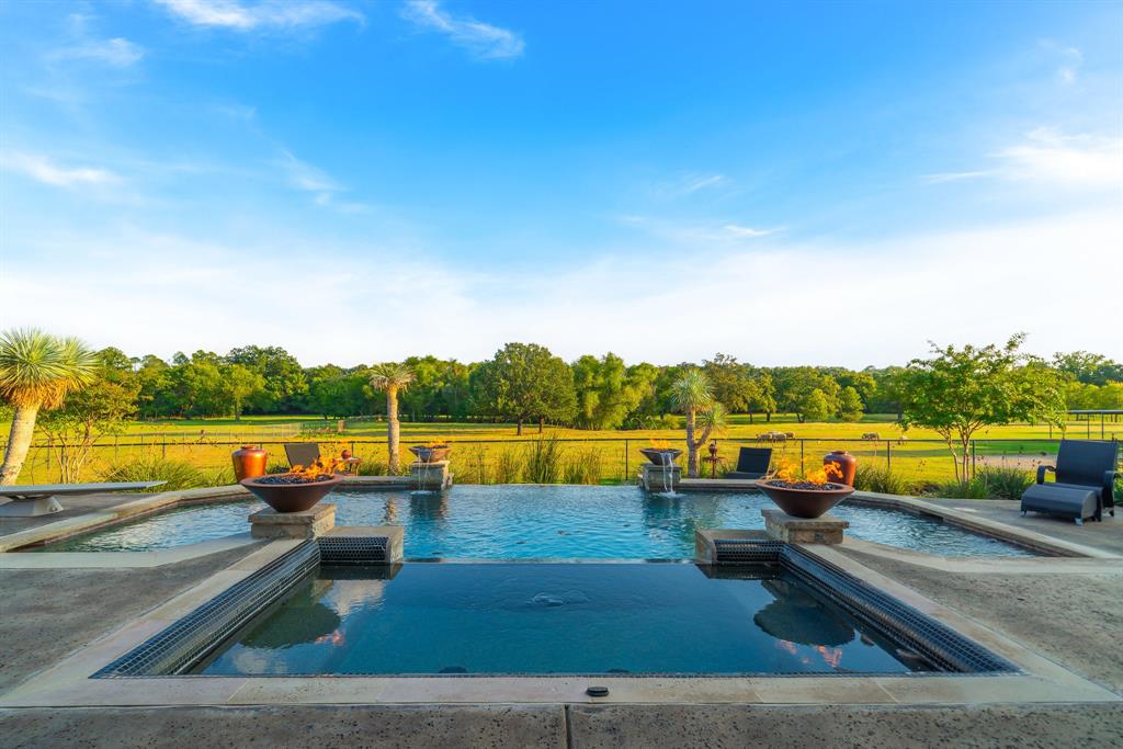 STUNNING private estate on 17.44 acres(14.94 Ag exempt)of mature landscaping, cross fenced pastures, water features & majestic trees. Located Argyle Tx & only minutes from city amenities. This private estate is gated & includes a pond,4 stall barn & hay barn. The property consist of 2 parcels providing the perfect combination of privacy, trees & rural living. Meander the tree lined gated drive, passing water features & free range Peacocks to the luxury home that is an open layout with custom & designer features through out the home & a dedicated study & game room set for entertaining! Your dream kitchen has quartzite counter tops,2 dishwashers,2 sinks & working walk in pantry. For the CAR ENTHUSIAST, the 5 car attached garage has epoxy floors and built in cabinets. A 2 car bay is walled separately & is full HVAC. Enter your backyard oasis with negative edge pool, mature landscaping decking & fireplace that overlook this incredible property. Take a deep breath, you are home.