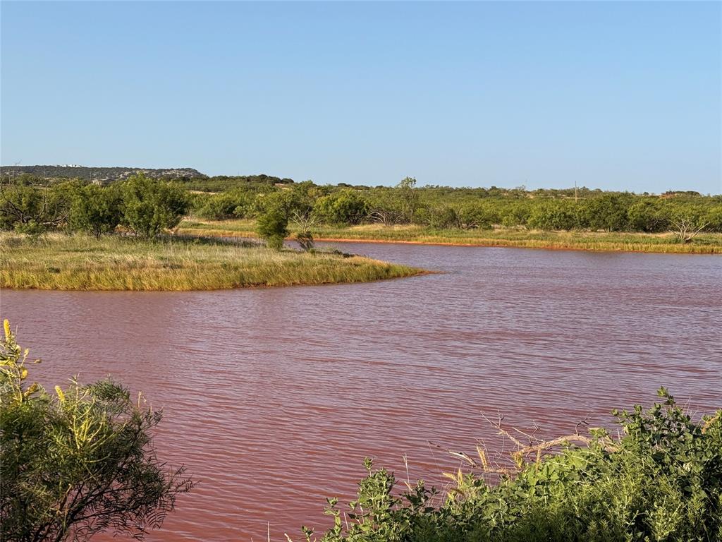 Build your dream home on this beautiful 53-acre tract in highly sought-after Taylor County, located within the desirable Jim Ned ISD. Featuring level to gently rolling terrain, this property offers several outstanding homesites with panoramic views of spectacular West Texas sunsets, colorful sunrises, Steamboat Mountain, and Double Gap Mountain. An outstanding and picturesque stock tank and a seasonal portion of Elm Creek meanders through the property, creating a scenic natural feature that enhances the landscape and attracts local wildlife. Enjoy the tranquility of country living with the convenience of paved FM road frontage. A feasibility study has been completed, a water meter is available, and electricity is located along the FM road, making this property ready for your custom home or weekend retreat. Whether you're looking for a peaceful homesite, recreational acreage, or a long-term investment, this property offers the perfect combination of beautiful scenery, convenience, and wide-open space. Additional acreage is available for those looking to expand. Buyer to verify all utilities and schools.