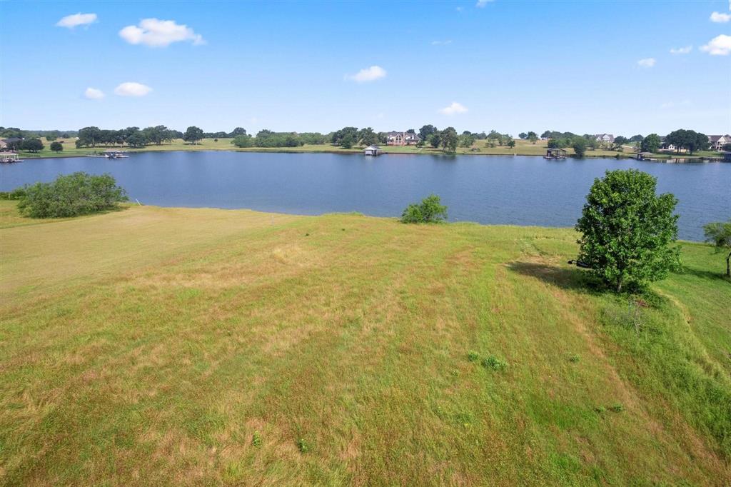 Tucked behind the gates of Southpoint lies a rare 1-acre lakefront lot West facing corner lot with 100 feet of pristine shoreline—ready for your dream home. Geological survey and soil tests are complete, and 30-amp electric is in place. RVs are welcome for up to 14 days a month, offering flexibility while you build or unwind.  Nestled in a protected cove, on Richland Chambers Lake—the third largest in Texas—this serene property offers panoramic views and shelter from open-water storms. Imagine glass walls facing the lake, a porch that captures every sunset, and mornings that begin with reflections from your private dock.  Southpoint is a gated community known for quiet luxury, featuring a pool, private boat launch, and gazebo. Just 1.5 hours from Frisco, this lot is one of the few true lakefront properties available.