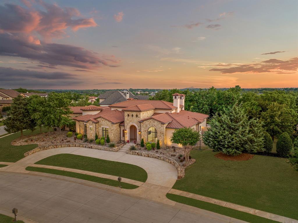 Nestled on an expansive .95 corner lot, this exceptional ONE-STORY estate offers refined living in the prestigious, guard-gated community of Granada. With 4 spacious bedrooms, a  4-car garage, and thoughtfully designed living spaces, this home blends elegance with everyday functionality. The heart of the home is an impressive great room with soaring 22' vaulted ceilings, flowing effortlessly into a show-stopping chef’s kitchen featuring Wolf and Sub-Zero appliances, a Taj Mahal quartzite island, and Calcutta Royal Quartz countertops. A 1,500-bottle, temperature-controlled wine cellar adds a sophisticated touch for the avid entertainer or collector. The serene Master suite features a luxurious spa-style bath with Calcutta marble, a private courtyard and his and her closets. A flexible bonus room serves perfectly as a home gym or second office.Outdoors, enjoy your own private resort-style oasis with a sparkling pool and spa, fire pit, covered lounge areas —ideal for year-round relaxation. Zoned to Westlake Academy or CISD. this estate offers the ultimate in privacy, prestige, and comfort in one of Westlake’s most sought-after neighborhoods.
