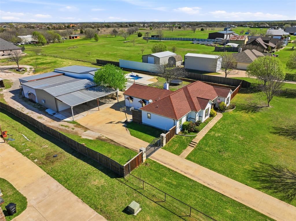 SELLER OFFERING UP TO $10,000 Consession! If you’ve been looking for space, flexibility, and the freedom of country living, this property checks all the boxes. Situated on 1.61 acres outside the city limits with NO HOA, this FULLY FENCED and GATED property offers privacy, room to work, and plenty of space to enjoy. Inside the home, you’ll find 4 bedrooms, 2 full bathrooms, and a versatile floor plan designed for both everyday living and entertaining. The open layout offers great flow between the main living areas, with a second living room that can easily function as a bonus room, game room, or additional family space. Two dedicated office areas make working from home easy or provide flexibility for hobbies, homeschooling, or extra storage. The updated kitchen features granite countertops and opens nicely into the main living areas, making it ideal for gathering with family and friends. Both bathrooms have been updated, and the split bedroom layout provides privacy for the primary suite. The home also features walk-in closets, tile flooring throughout the main areas, and fresh new carpet in the bedrooms. Step outside and enjoy your own backyard retreat with an in-ground pool complete with water features and a slide. For those needing workspace or storage, the property offers three separate workshops, one of which includes its own bathroom. Whether you need room for equipment, hobbies, a home business, or extra parking, you’ll have plenty of options here. Additional features include full spray foam insulation in the attic for energy efficiency and a property layout that offers both privacy and functionality.