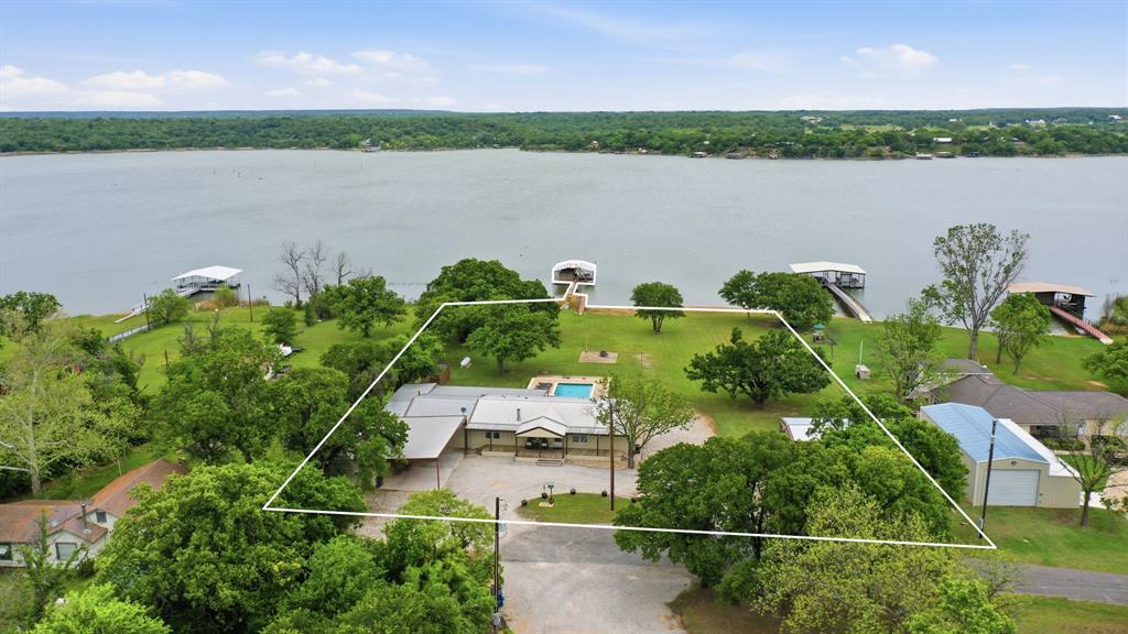 Lake season is right around the corner—and this lakefront property on Lake Leon is ready to deliver the lifestyle you’ve been waiting for.
Unobstructed views of Lake Leon from your backyard!
This 4-bedroom, 3-bath home isn’t just a place to live—it’s a place to unwind, entertain, and make lasting memories. From sunrise coffee on the water to sunset gatherings with friends, every detail is designed for comfort and enjoyment.

Step outside to your private backyard retreat featuring a sparkling in-ground swimming pool and an oversized hot tub—perfect for relaxing after a long day on the lake. The enclosed back porch area features an amazing heated outdoor kitchen space with beautiful stonework and stainless appliances! 
There is also a huge bonus room complete with a wet bar and it's own bathroom!
Stay active and refreshed with your own dedicated workout room complete with a dry sauna—bringing a spa-like experience right into your home. And for lake lovers, there is a private boat ramp and dock with boat lift and cover that makes getting out on the water effortless anytime you want.  The large lot has beautiful mature oaks and even covered RV parking!

Properties like this don’t come along often—especially just in time for lake season. If you’ve been dreaming about lakefront living, now’s your opportunity to make it a reality.

Come see it, feel it, and make it yours.
There is additional acreage with a shop, tiny home and storage buildings available directly across the street at an additional price.  Contact agent for details and pricing.