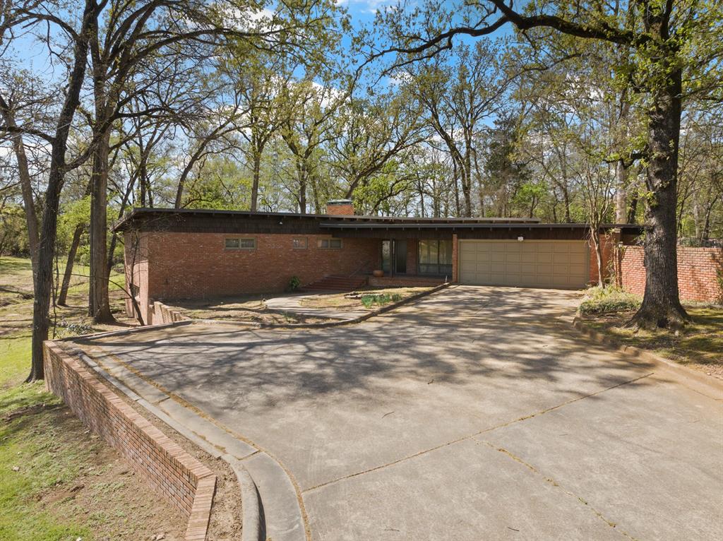 Step into your mid-century modern dream! Beautifully situated on a 3.3 acre corner lot in one of the area’s most sought after neighborhoods, this split-level home blends timeless charm with spacious, functional living. The main level welcomes you with a generous formal living room anchored by a stunning fireplace, perfect for gathering and relaxing. On this level, you’ll also find three well appointed bedrooms and two of the three bathrooms, all conveniently located for easy everyday living anda gorgeous sunroom lined with windows allowing ample natural light, ideal for sipping your morning coffee while enjoying the views. Downstairs is an entertainer's dream. Complete with a full wet bar, an additional fireplace, a full bathroom, and a patio off the back, this space is perfect for hosting parties, hanging with friends, or slipping off to your own private retreat. You’ll appreciate the retro charm of terrazzo tile floors throughout the home, abundant built-in storage, and classic mid-century details that make this property truly special. Additional features include a two car garage and a separate workshop, ideal for hobbies, projects, or extra storage. A rare opportunity to own a one-of-a-kind property with character, space, and style! Don’t miss it!