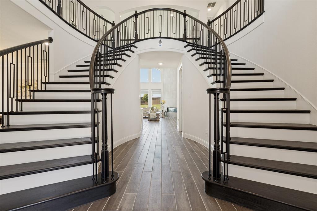Experience refined sophistication in this meticulously crafted Grand Homes masterpiece, ideally situated in the heart of McKinney's highly sought-after Wilmeth Ridge community. This stunning 6-bedroom, 5-bathroom residence offers 4,851 square feet of thoughtfully designed living space, seamlessly blending timeless elegance, modern innovation, and exceptional energy efficiency.
From the moment you enter, you're greeted by soaring ceilings, abundant natural light and a dramatic dual staircase that creates a truly grand first impression. The gourmet chef's kitchen showcases a KitchenAid commercial-grade, large 6-burner gas range with a warming area, an oversized island, sleek 42-inch cabinetry, a spacious walk-in pantry, and an adjacent wet bar perfect for hosting family and friends.
The beautifully designed floor plan offers exceptional flexibility, featuring a private main-level guest suite that can serve as a luxurious mother-in-law retreat or executive home office. Upstairs, you'll find generously sized secondary bedrooms, multiple living areas, a spacious game room, and abundant storage throughout, providing ample room for relaxation, entertainment, and growing households.
Attached 2-car garage adds everyday convenience. Enjoy an exceptional lifestyle surrounded by a private lake, mature trees, resort-style swimming pool, playground, pocket parks, scenic hike-and-bike trails, and a community fire pit. Ideally located just minutes from The Star, PGA Headquarters, and the highly anticipated Universal Kids Resort, enjoy premier shopping, dining, entertainment, and recreation. Zoned to acclaimed Prosper ISD schools, including Rock Hill High School, with convenient access to the Dallas North Tollway, US-380, and Highway 75.
Don't miss your opportunity to call this exceptional McKinney home your own—schedule your private showing today.