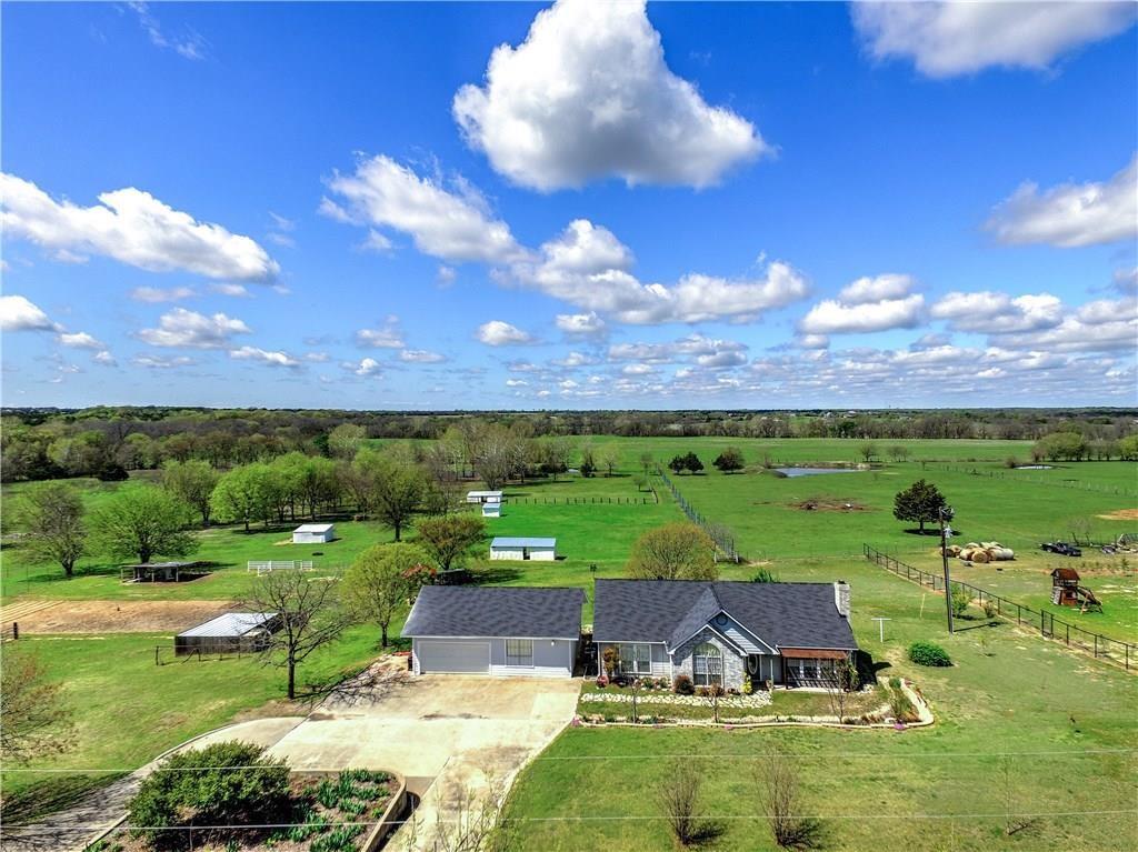 Enjoy the best of country living on 11 acres with amenities designed for both comfort and functionality. This property features multiple fenced and cross-fenced pastures, a stocked pond, and horse-ready improvements including holding pens, loaf sheds, and a tack room. Additional amenities include multiple outbuildings with water access, a workshop- mudroom, 220V powered detached garage, and a storm shelter for added safety.
The home offers vaulted ceilings, granite countertops, tile backsplash, and a covered deck perfect for relaxing and taking in peaceful views. The landscaped yard includes mature trees, fruit trees, and a garden space. With Agricultural Exemption in place and room to expand, this property is ideal for equine use, hobby farming, or a private retreat lifestyle.