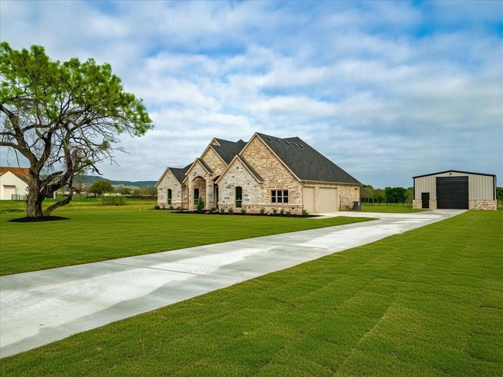 Need a WORKSHOP with your home?? FREE WATER?? This 2+ acre energy efficient, new build property is serviced by a WATER WELL. It features a 3-car garage, extended concrete drive, and an impressive 30×40 workshop with electric, 12×14 commercial door, side-mount lift system, LED lighting, 50-amp plug, and 20-amp circuit. Interior features include GE Profile app-controlled appliances, large farm sink, kitchen undermount and uplighting, pendant lighting, trash drawer, and an office. Enjoy both indoor and outdoor wood-burning fireplaces. The luxury primary suite offers tray ceiling with colorchanging remote control rope lighting, a garden tub, walkthrough shower, and a custom oversized closet. Additional upgrades include engineered foundation, water heater, 17-SEER Trane HVAC, LED lighting, and FULL SPRAY FOAM INSULATION INCLUDING THE ATTIC, beverage cooler, wifi appliances, and 100 gallon propane tank for cooktop, and sprinkler system around home perimenter and front yard.