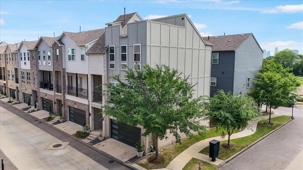 Corner lots are rare in Soho Square. One with a rooftop open-air patio and nearly 360-degree views of the Dallas skyline? Even rarer. Welcome home.

Situated in the sought-after Soho Square Phase 1 community in the heart of Trinity Groves, this contemporary 3-bed, 3.5-bath townhome sits on one of the community's prime corner positions — extra natural light, extra breathing room, and a rooftop experience that most neighbors simply don't have.

The main living level is open and inviting, anchored by a well-appointed kitchen with a gas range, quartz countertops, and a generous island that's as functional as it is stylish. Wood floors, high ceilings, and a walk-out balcony round out the space perfectly. The floor plan is thoughtfully laid out — a bedroom and full ensuite bath on the main level sits completely separate from the upper bedrooms, giving guests or extended family their own private space to come and go without ever being in each other's way. The primary suite delivers a true spa-like retreat with double vanities and an oversized shower, and the additional upper bedroom has its own ensuite and walk-in closet as well.

Out back, a low-maintenance turf yard keeps things easy. The attached two-car garage handles the rest. And up top, that rooftop patio is the real headline — open sky, sweeping city views, and your own piece of the Dallas skyline.

The Soho Square lifestyle only keeps getting better: resort-style pool, hot tub, full gym, bowling alley, and clubhouse — all on-site today, with a lagoon-style resort pool in the works for the future. Step outside and Trinity Groves dining is right there. Bishop Arts, Oak Cliff, and Downtown Dallas are minutes away. The Trinity River Trail is nearby for morning runs and dog walks, and major highway access puts all of DFW within easy reach.

This one checks boxes most homes in the community simply can't.
