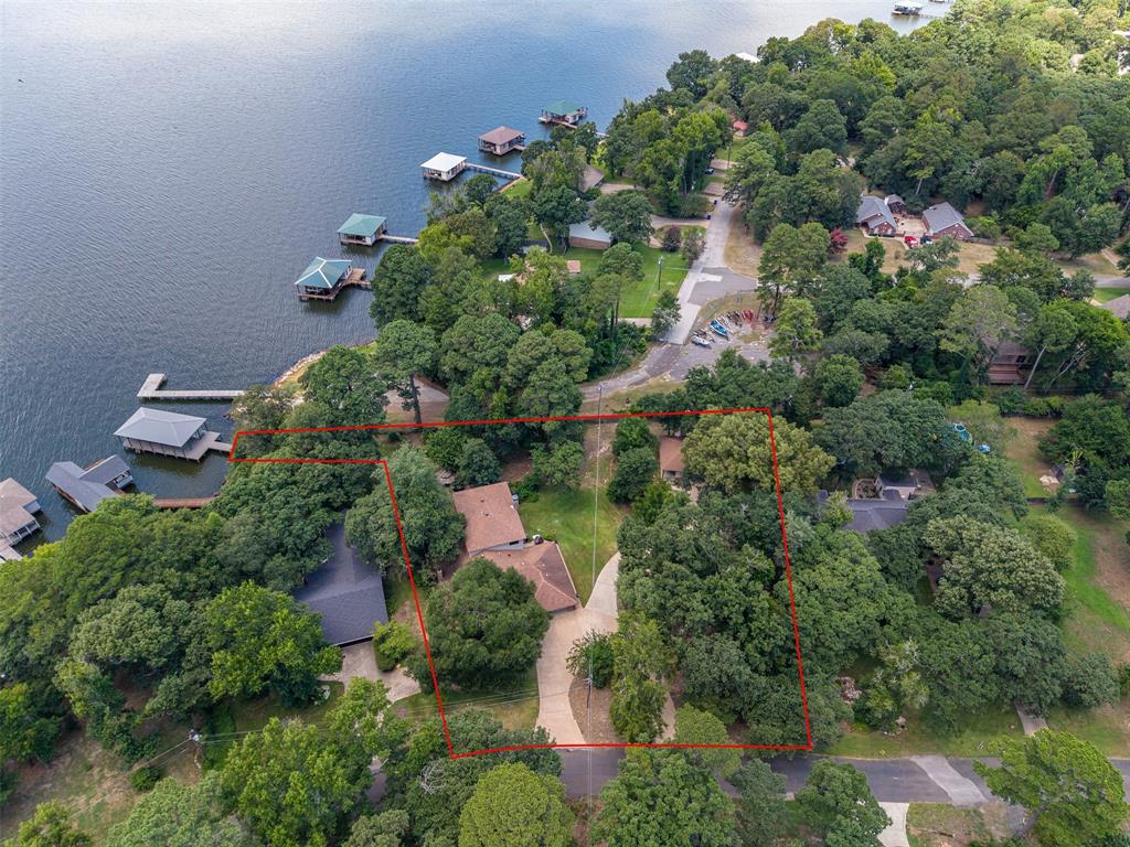 The ultimate property on Lake Palestine in Bullard ISD! Spanning an expansive 0.95-acre double lot, this homesite blends open spaces, premium amenities, and true architectural foresight. The beautifully updated primary residence features 3,661 +- heated & cooled sq. ft. completely configured for effortless luxury and stunning water views.

The masterfully designed floor plan separates entertaining spaces from private quarters, highlighted by the magnificent upstairs primary suite. Positioned perfectly on the upper level, this master retreat offers breathtaking, elevated panoramas of the lake and includes a spa-like bathroom complete with custom radiant heated flooring. Downstairs, you will find light-filled living areas, wall-to-wall window lines framing the water, 3 cozy fireplace options, and a dedicated area structured to easily accommodate a future elevator if ever needed. For total peace of mind during Texas weather, the main home is completely supported by a whole-house backup generator.

Step outside to explore your private acreage, featuring 30 feet of direct shoreline with seamless lake access and your own covered boathouse. Across the meticulously manicured grounds sits a second incredible asset: a fully insulated detached shop equipped with its own convenient bathroom (toilet and sink). This space is perfect as a high-end workshop, climate-controlled toy boat storage, or a detached hobby hub. Enjoy relaxing or hosting gatherings on the expansive patio while taking in cool lake breezes.

Offering unmatched privacy via its dual-lot footprint, stellar school zoning, and structural upgrades, this Hide-A-Way Bay gem stands entirely in a league of its own. Schedule your private tour today!