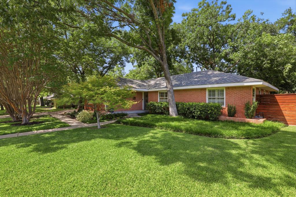 Beautifully maintained and located in the charming enclave of Emerald Isle, this exceptional home offers the perfect blend of comfort, style, and an unbeatable East Dallas location. Surrounded by mature trees and beautifully landscaped streets, the neighborhood features a private walking path with direct access to White Rock Lake and Lawther Drive, and is just a short stroll to the Dallas Arboretum, neighborhood restaurants, coffee shops, weekend Farmers Market, and more. Gorgeous curb appeal welcomes you with lush landscaping and towering shade trees. Inside, the open-concept great room creates an inviting space for everyday living and entertaining, featuring spacious living and dining areas that flow seamlessly into the kitchen while overlooking the backyard and sparkling lap pool. Rich hardwood floors extend through most of the home, and the dining area is accented by a fireplace. The kitchen offers granite countertops, bar seating, a gas range, built-in microwave, warming drawer, new dishwasher, and abundant cabinet storage. The private primary suite overlooks the backyard and pool and features two closets along with a beautifully updated bath complete with a standalone soaking tub, furniture-style dual sink vanity, and a large frameless walk-in shower. Two secondary bedrooms overlook the front lawn through oversized plantation shutter-covered windows that fill the rooms with natural light. The updated guest bath features a new vanity, stylish tile, and a spacious walk-in shower. Just off the kitchen are the laundry room and an oversized storage closet not included in the home's square footage. Situated on a one-third acre lot, the backyard offers mature trees, lush landscaping, and a lap pool with an automated cover. Emerald Isle is known for its welcoming community spirit with neighborhood traditions including a Halloween party, Progressive Holiday Dinners, and residents proudly maintaining an adopted section of White Rock Lake. New Roof 2026