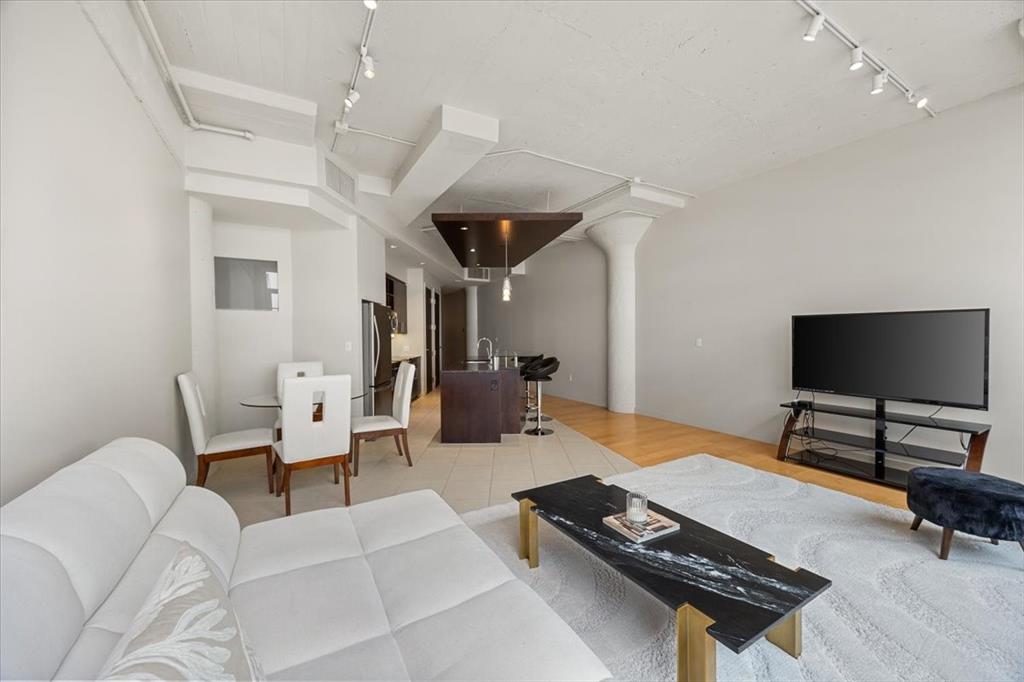Enjoy the carefree, lock-and-leave lifestyle in this beautifully appointed 1 bedroom, 1 bath residence featuring 1,263 sq ft of spacious, open-concept living. The kitchen and living area flow seamlessly, highlighted by an oversized island with breakfast bar, sleek tile backsplash, and wood and tile flooring throughout. The primary suite includes a bonus flex space, perfect for a home office or reading nook, along with a custom IKEA built-in wardrobe, spa-inspired bathroom, and designer wall coverings. Electric shades in the living area add a modern touch, while expansive windows offer stunning views of 7th Street and the vibrant Montgomery Plaza corridor. This home comes with two reserved parking spaces and access to an array of luxury amenities, including a 24-hour concierge, resort-style pool with cabanas, state-of-the-art fitness center, private movie theater, and elegant resident lounges. Located in the tower closest to the dog park, this unit offers convenience and comfort in one of Fort Worth’s most desirable communities.