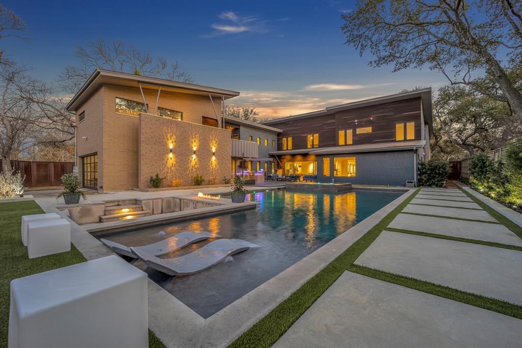 Set beneath a canopy of mature live oaks on a beautifully landscaped .44-acre lot, 5947 Meadow Crest offers a rare blend of privacy, scale, and architectural clarity in the heart of Preston Hollow. Built in 2013, this modern estate stands apart from today’s new construction—offering established grounds, expansive outdoor living, and a level of tranquility that simply can’t be replicated. A sleek steel privacy fence frames the property, creating a true sense of retreat just minutes from the city’s best dining, schools, and shopping. Inside, walls of glass flood the home with natural light while thoughtfully positioned for privacy. The open-concept living spaces flow seamlessly, anchored by clean architectural lines and designed for both everyday living and elevated entertaining. A central gallery leads to the private owner’s retreat, offering an ideal backdrop for art collectors or those who appreciate intentional design. The kitchen connects effortlessly to the main living areas, while a spacious mudroom and integrated built-ins add functional ease throughout the home. Outdoors, the property truly shines. A custom pool, lush landscaping, and a rare 20-foot side yard create multiple spaces for entertaining and play. The sunken conversation pit serves as a striking focal point—perfect for evenings by the fire under the trees. A fully finished guest suite above the garage, complete with a walk-in closet and full bath, offers flexibility for guests, a private office, or multigenerational living. For buyers seeking modern architecture with warmth, privacy, and a setting that feels established—not newly built—this is a rare opportunity in one of Dallas’s most coveted neighborhoods.