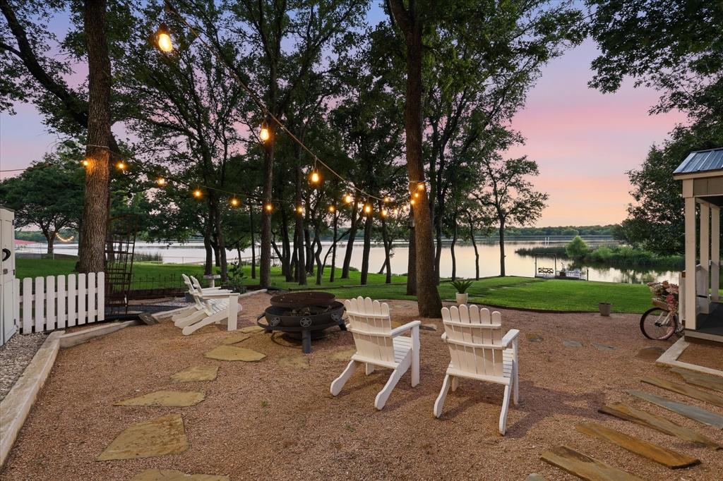 FULLY FURNISHED WATERFRONT RETREAT with Private Boat Ramp, Fishing Dock, Workshop & She Shed! Experience lakefront living on Lake Alvarado. This renovated & fully furnished waterfront home offers 90 feet of shoreline, a private concrete boat ramp, & a custom fishing dock complete with a porch swing—the perfect spot to cast a line, relax, & enjoy breathtaking sunset views.  Originally transformed beginning in 2021, this charming farmhouse-style home underwent an extensive renovation with new walls, ceilings, flooring, doors, windows, kitchen, bathroom, HVAC, water heater, refurbished septic system, fireplace upgrades, foundation improvements with nine drilled piers, & fresh interior & exterior paint. A new roof was installed in 2024 & includes a transferable 30-year warranty.  Inside, you'll find a living room with a wood-burning fireplace, dining area, & an inviting galley kitchen. The home features two bedrooms, though the second bedroom can easily serve as a sunroom or bonus room thanks to its abundance of windows & incredible lake views. Outdoor living is where this property truly shines. The expansive lakeside deck is ideal for entertaining & features a unique minnow-bucket chandelier. Mature trees, landscaping, & a lake-fed irrigation system enhance the setting. Two insulated outbuildings with electricity & air conditioning provide exceptional flexibility—one serving as a workshop-man cave & the other as a charming, fully furnished she shed.  Beyond the sunsets & waterfront recreation, this property offers a seat to nature. Watch pelicans migrate in each winter, observe ducks gathering along the shoreline, & enjoy feeding catfish from your private boat ramp. Duck feed & floating catfish food will be left for the new owners to continue this unique lakeside tradition.  Ideal as a weekend getaway, vacation rental opportunity, or full-time lakefront residence, this move-in-ready property offers the perfect combination of comfort, character, & waterfront recreation.