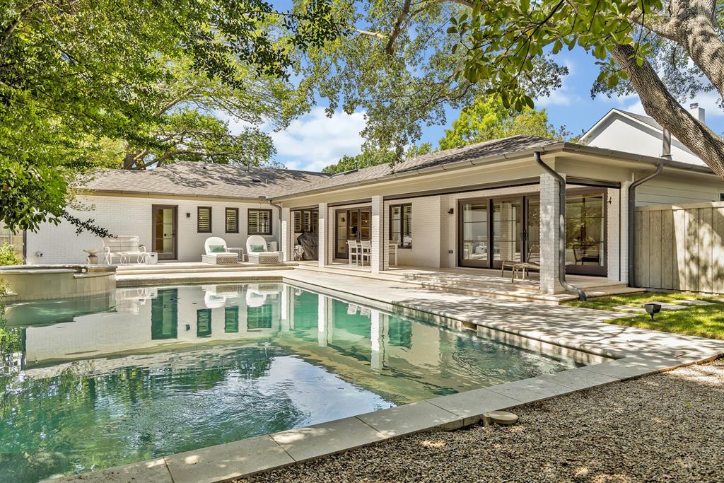 A true Lakewood masterpiece, this one-of-a-kind residence was completely reimagined and expanded in 2023, offering an unparalleled combination of modern sophistication and timeless design. Nestled on an expansive .335-acre lot, this rare single-story ranch is framed by lush landscaping and bathed in natural light from walls of windows that blur the line between indoors and out. At its center, the chef’s kitchen serves as both a statement of style and a culinary dream, showcasing Taj Mahal quartzite countertops, top-of-the-line appliances including a built-in refrigerator, an oversized pantry, and a sunlit breakfast nook. The primary suite defines luxury living with its own fireplace, French doors leading to the backyard, and a spa-inspired bath with soaking tub, standalone shower, and custom-designed closet system. No detail was overlooked in the redesign, with exquisite finishes including designer lighting and tile, rich wood flooring, exposed beams, and three fireplaces that add warmth and character. The floor plan was thoughtfully curated for flexibility, offering multiple living areas, a dedicated office, an exercise room, and a custom-built bonus room currently serving as an art studio. Outdoors, this private sanctuary is designed for both intimate gatherings and grand entertaining with a resort-style pool and spa, expansive covered patio with ceiling fan and motorized screens, and manicured grounds secured by a board-on-board privacy fence. An oversized two-car garage and solar panels adds practicality without compromising elegance. Perfectly positioned and zoned to Lakewood Elementary, this home is more than a residence—it is a statement of refined living in one of Dallas’ most coveted neighborhoods.