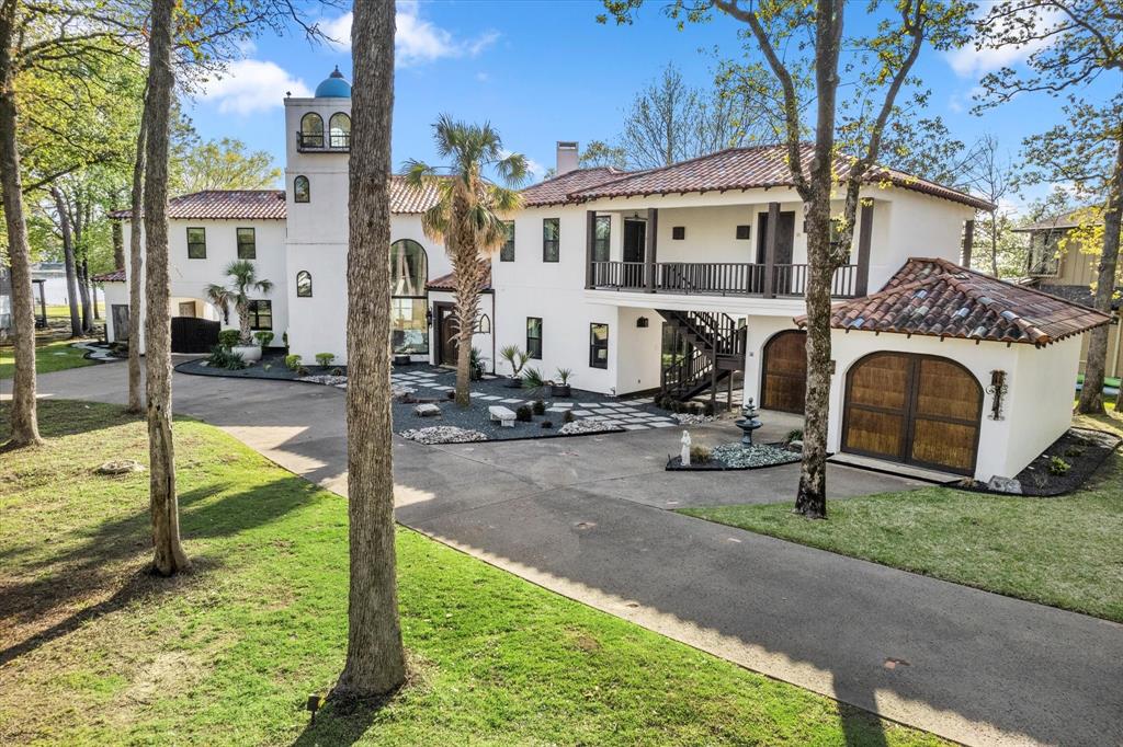Contemporary meets Spanish Revival in Pinnacle Golf Club! This exquisitely remodeled waterfront home is a legacy property that will be passed down to generations. Located on 223 feet of shoreline with a rare private beach, this is an entertainer's paradise. 25+ foot high ceilings with the best tower welcome you into the open living and kitchen areas, all with open water views. Your family will love the six bedrooms, six full ensuite bathrooms, tremendous space for guests, and the best sunset views on CCL. The primary suite and bathroom is truly a marvel: providing a rare his and hers bathroom connected by a large double-sided walk-in shower. Connected guest casita allows space and intimate privacy for family, adult parents and friends. Lakeside professionally installed artificial grass putting green, rough, and green side bunker is great for private practice. Large boathouse with two boat slips and two PWC lifts. See agent for Buyer's transfer fee and golf memberships. Yard sign 103.