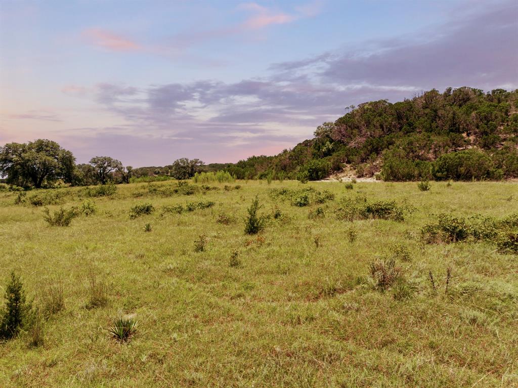 Welcome to Cedar Ridge Ranch, approximately 247 acres in Cranfills Gap, Texas, located in Hamilton County. The ranch is situated in the scenic Goar Valley west of Cranfills Gap, near the Bosque and Hamilton County line. This historic property dates back to 1828 when the Goar family acquired it from native inhabitants of the area for a single saddle. While the Goar Valley schoolhouse once stood here, no remains exist today. The current owners have cherished the property since 1995. Cedar Ridge Ranch offers a mix of recreational and productive farmland. With a 120-foot elevation change, the property provides stunning views from the mountaintop. The ranch features two entrances: one on paved Highway 22 and the other on County Road 309. A long, picturesque driveway lined with century-old oak trees leads to the ranch house, where a windmill will greet you.

The 3-bedroom, 3-bathroom home boasts an open-concept kitchen and living area, perfect for entertaining, and a bonus sunroom that floods the house with natural light. The property features a charming horse barn with runs and five well-maintained pastures, currently leased for hay production (Kleingrass). Additionally, there is a set of cattle working pens. The ranch is easy to navigate and provides access to the mountaintop, where strategic clearing has created a beautiful pasture along with several potential building sites. Water features include two stock tanks: one stocked with catfish and another filled by a year-round spring-fed creek. Whether you’re looking for a property for cattle, hunting, a weekend getaway, or the perfect spot to build your dream home with breathtaking views, Cedar Ridge Ranch has it all! 

Property to be surveyed. An additional 124 Acres is available for sale with farmhouse.