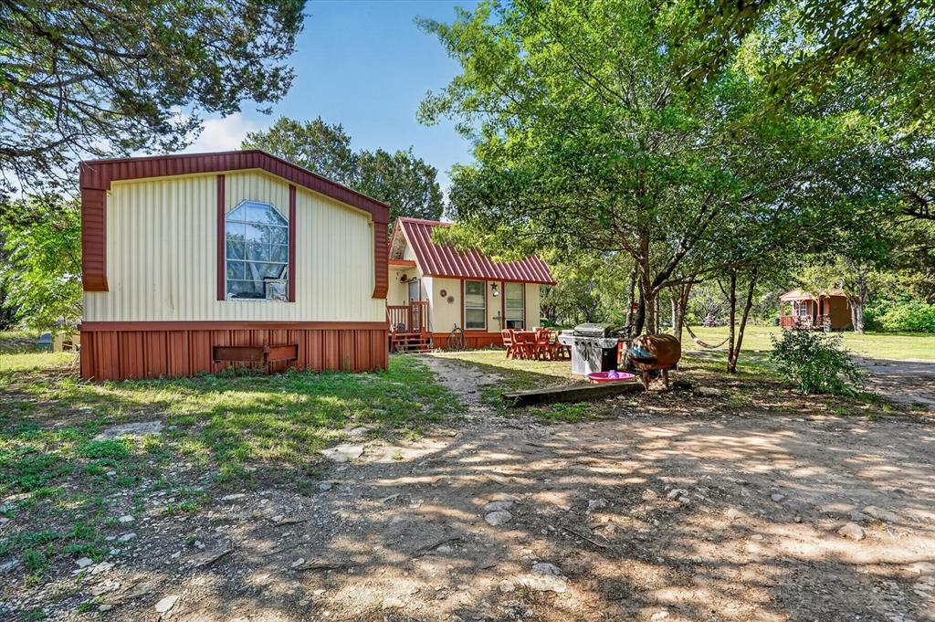 Nestled on 3.15 tree-covered acres, this unique Granbury property offers privacy, versatility, and endless potential. The approximately 1,300 sqft main home is complemented by two additional cabins, creating the perfect setup for multi-generational living, guest accommodations, rental income, or hobby space. One cabin features 2 bedrooms, 1 bathroom, a kitchen, and washroom, while the second cabin provides excellent storage or workshop potential. Surrounded by mature trees and peaceful scenery, this property offers the feel of country living while remaining conveniently located near Granbury amenities. Whether you are looking for a full-time residence, weekend retreat, or investment opportunity, this property offers flexibility and room to make it your own. Property is being sold AS-IS, WHERE-IS.
