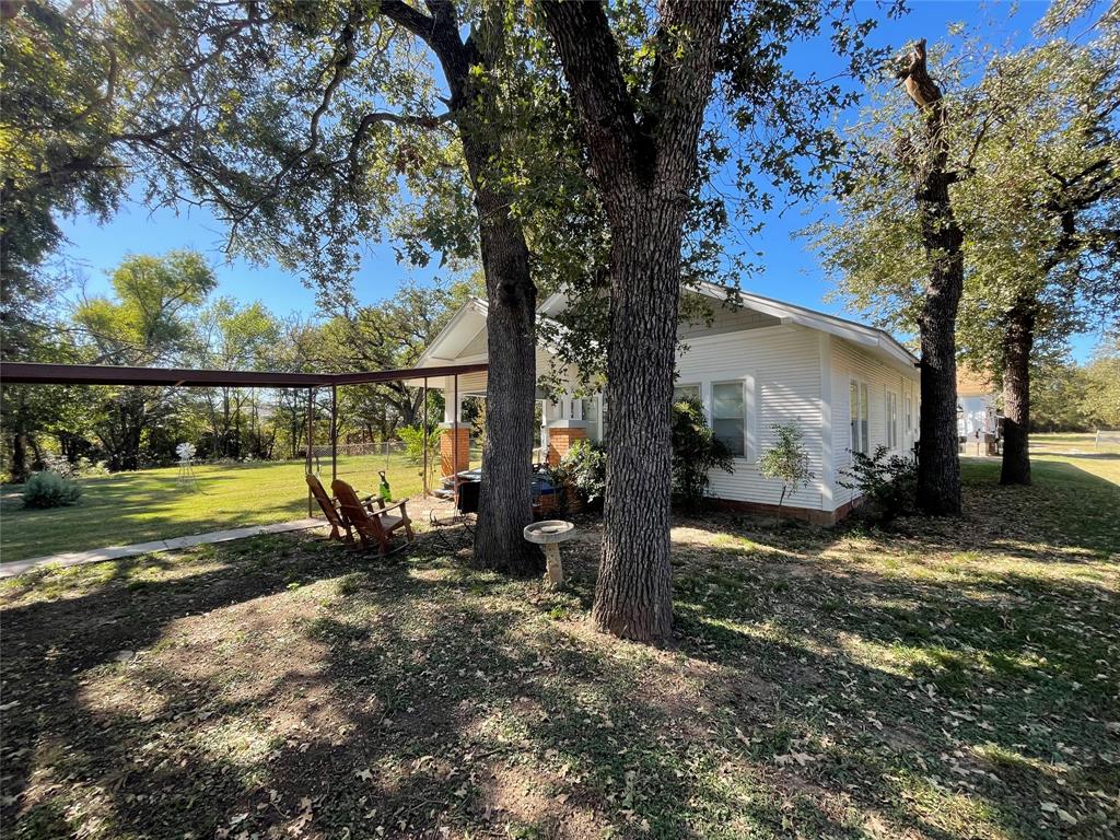 This exceptional property offers the ideal blend of rural living and metropolitan access. Located close to Santo schools and just a short drive from I 20, you'll have an easy commute to the Fort Worth Dallas area.
The property is a dream for those needing space for hobbies or business, featuring multiple shop buildings. The house also has 2 rooms that could be turned into bedrooms as only 2 are currently being used as bedrooms. Parking is ample with a small covered area perfect for a family sized car at the front of the property. In the back, a large carport provides additional covered parking.
The generous, huge backyard is ready for outdoor activities and is accessed via a dedicated dirt road leading to the back and the carport. The setting is naturally enhanced by a small, seasonal creek bordering the property on one side.
A significant feature is the property's dual water system: the house runs on city water, while the well and well house are already plumbed to maintain the grass, multiple producing peach trees, and other garden facilities, offering great flexibility and cost savings. Don't miss this rare opportunity for space, location, and utility!