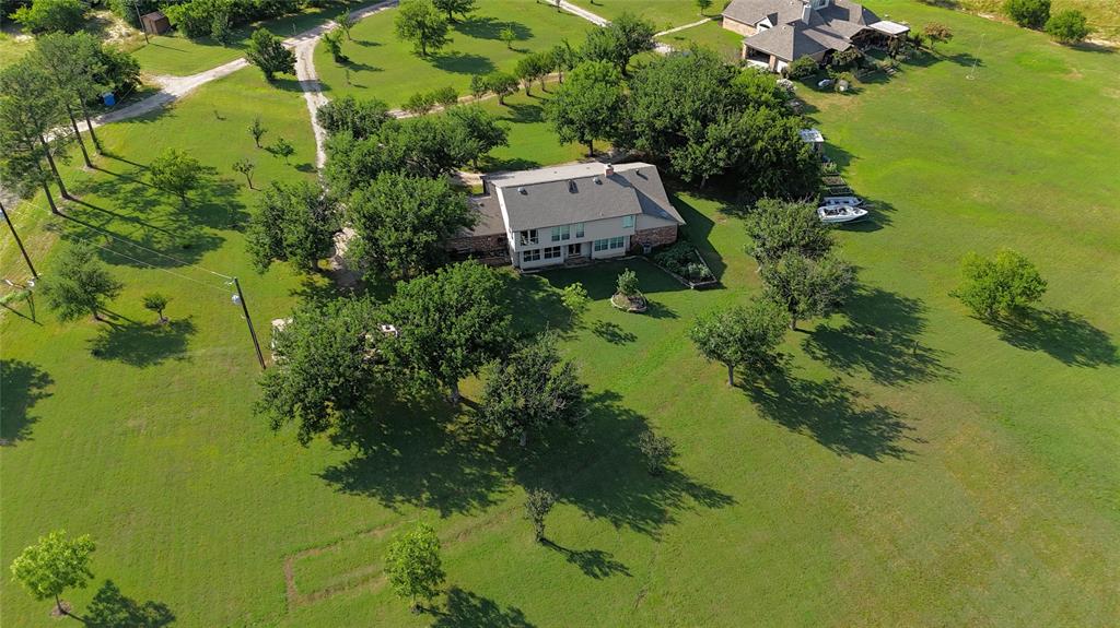 Experience breathtaking views of Lake Lewisville from this secluded 2.48-acre waterfront estate, on a private road, minutes from the Dallas North Tollway, PGA Headquarters and the planned Universal Theme Park in Frisco! This 5-bed, 4-bath home features an open floor plan with bay windows and an upper-level guest suite highlighting the panoramic views of nature at it's best.   The manicured lawn with ample shade trees provides the perfect setting for relaxed lakeside living, boating, fishing and outdoor gatherings. This enchanting location is your perfect oasis, blending the tranquility of country life with city convenience!