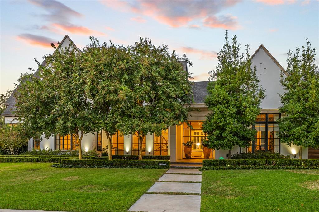 This stunning transitional home, crafted by Robert Elliott Custom Homes and updated by Sees Design, combines style and comfort in 6,680 square feet. Featuring 5 bedrooms, 5.1 bathrooms, and a beautiful outdoor oasis, it’s perfect for both everyday living and entertaining. Flooded with natural light from floor-to-ceiling windows and a custom steel entry door, the home offers a welcoming sitting room and large dining area that leads into a spacious bar. The inviting family room opens to the kitchen and breathtaking backyard. The chef’s kitchen boasts Wolf and Subzero appliances, a walk-in pantry, and a cozy breakfast nook. Downstairs also includes a private study connected to its own peaceful patio, plus a guest suite with a full bath that directly accesses the outdoors. Upstairs, the primary suite offers a spa-like bath with dual vanities, a claw-foot tub, and a large custom closet. Three additional bedrooms, each with an en-suite bath and walk-in closet, a study nook, and a spacious game room complete the second floor. The backyard is a true retreat designed by Archiverde Landscape Architecture and lined with mature magnolia trees. The pool and spa offers a relaxing water feature and a retractable cover. The covered patio, complete with infrared heaters and Haiku fans, is ideal for outdoor dining. The summer kitchen is equipped with all Kalamazoo cabinetry and appliances, including hybrid fire grill, pizza oven, burners and beverage fridge. Additionally, the gas fire pit, ipe decking, Calcutta stone countertops, and steel arbor pergola make it perfect for entertaining. Additional features include a gated driveway, an oversized garage with custom shelving, and a prime location near Preston Hollow Village and North Park Mall. This home offers a seamless blend of elegance and comfort, creating the perfect space for modern living.