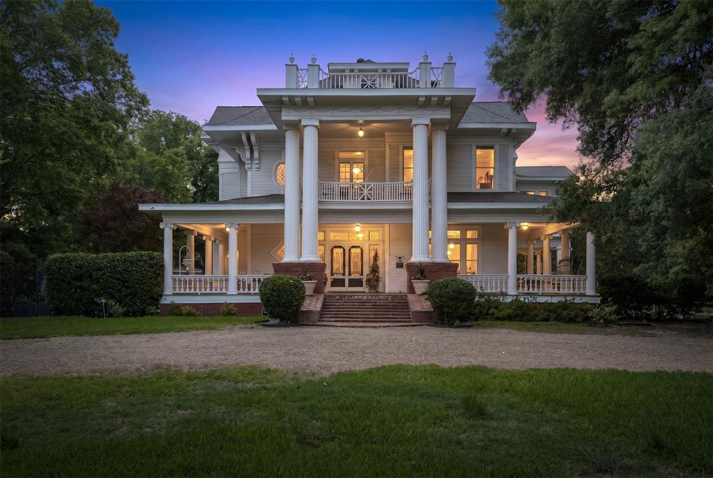 In the heart of Ennis, where historic homes line the streets & time slows just enough to be noticed, 400 W Denton stands as one of the city’s most remarkable residences. Positioned on over 1 acre, this historic home listed on the National Register of Historic Places is the kind of property buyers search for, but rarely have the chance to own. From the street, towering trees & expansive grounds frame the home, while the wide front porch invites you to settle in. Inside, the home reveals its craftsmanship in layers. Gorgeous, detailed woodwork, hardwood floors throughout, & original architectural elements create a richness that can’t be replicated. The rooms are generous in size & proportion, built for gathering, hosting, & living fully—echoing its history as a former bed and breakfast. The home offers large, open rooms & a flexible floor plan, designed in an era when homes were built for hosting. The spaces here are ideal for entertaining, multi-generational living, or creating a unique residence with income potential. The kitchen is a true centerpiece—designed for both function & presence. Equipped with double ovens, a Viking commercial-grade gas range, & two dishwashers, it’s a space that easily supports entertaining on any scale. Whether hosting holidays or weekend dinners, this is a kitchen that rises to the occasion. The possibilities continue with a basement & unfinished third floor, providing space for expansion—whether that’s guest quarters, studio space, useful storage, or a future business opportunity. Outdoors, the lifestyle continues with extensive patio areas, offering multiple places to gather, dine, & enjoy the setting. Combined with an oversized lot, the home creates a sense of space that feels both private & connected. Just minutes from downtown Ennis TX, you’re close to unique local shopping, dining, & community events. Since Dallas is only about 30 minutes away, this property offers a rare combination of historic charm, space, & proximity to DFW.