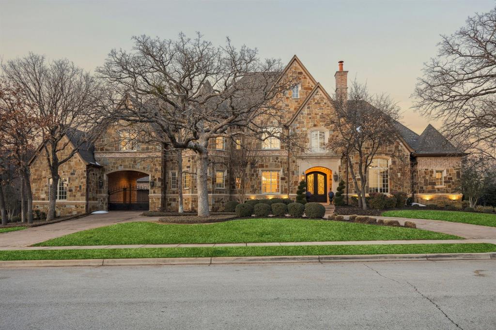 Exceptional by design, extraordinary by nature. Commanding a private, wooded sanctuary in the heart of Southlake's most coveted neighborhood, this 7,442 sq ft home presents a rare opportunity to experience refined living. Exemplary architectural distinction exudes luxury across 5 ensuite bedrooms & thoughtfully curated spaces designed for the most discerning homeowner. The gated porte cochère motor court establishes immediate distinction, offering privacy & a refined sense of arrival. Step inside to discover a thoughtfully designed floor plan featuring formal living & dining rooms adorned w elegant lighting, rich hardwood floors, and luxurious accents. The gourmet kitchen stands as a culinary masterpiece, showcasing premium appliances, an oversized island w leathered granite, & a walk-in pantry. The adjacent breakfast room provides an inviting setting for casual family meals, while the private study—complete with custom built-ins and a cast stone fp—offers a serene sanctuary for work. The 1st floor primary suite is a true retreat, featuring a cast stone gas fp, sophisticated dry bar, & spa-inspired ensuite with 2 vanities, walk-in glass shower, & soaking tub. The expansive closet w custom built-ins & dedicated gym space or nursery w patio access completes this luxurious sanctuary. A second first-floor ensuite bedroom accommodates multigenerational living or distinguished guests. Entertainment reaches new heights w the tiered media room on first floor, featuring professional lighting & custom projection screen, while the upstairs game room w wet bar & 3 additional ensuite bedrooms provide private retreats for family or guests.The outdoor spaces transform the grounds into a resort-style sanctuary. The covered patio showcases a complete outdoor kitchen, custom stone fp, & sparkling pool & spa surrounded by mature landscaping. This exceptional estate represents more than a home—it is a lifestyle statement where every detail delivers comfort, luxury, and functionality.