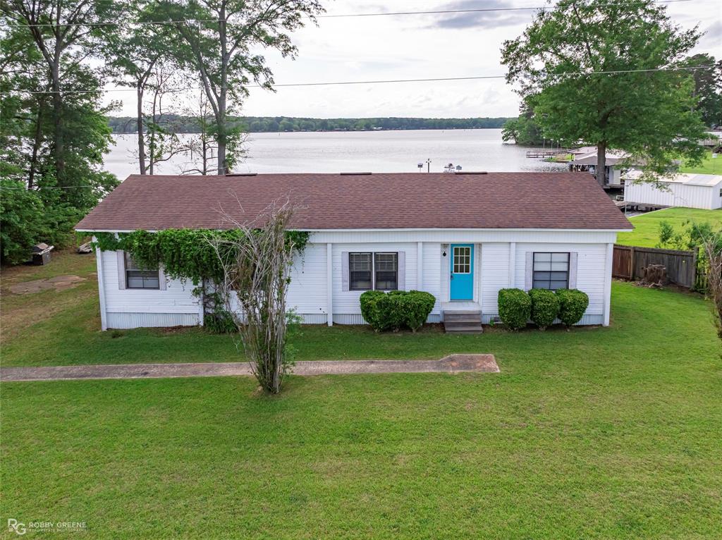 1589 Airport Loop in Homer, Louisiana is a 3-bedroom, 2-bathroom manufactured home offering 1,343 sq ft of living space on a 0.36-acre lakefront lot. Built in 1980, the home has undergone significant updates, making it a comfortable and move-in-ready retreat. Eat-in kitchen with an island, electric oven, microwave, and dishwasher.  Living room and dining room provide a functional, open layout. Two full bathrooms, both well-maintained.  Flooring includes hardwood, laminate, and linoleum for durability and easy upkeep.  Lakefront property with beautiful views, perfect for morning coffee or evening relaxation.  A private pier offers direct access for fishing and enjoying the water.  Covered porch-patio ideal for outdoor gatherings. Septic system was last inspected in April 2026. Roof was replaced in 2012.  Located in the D'Arbonne Beaver Subdivision, which includes community lake access and recreational opportunities.