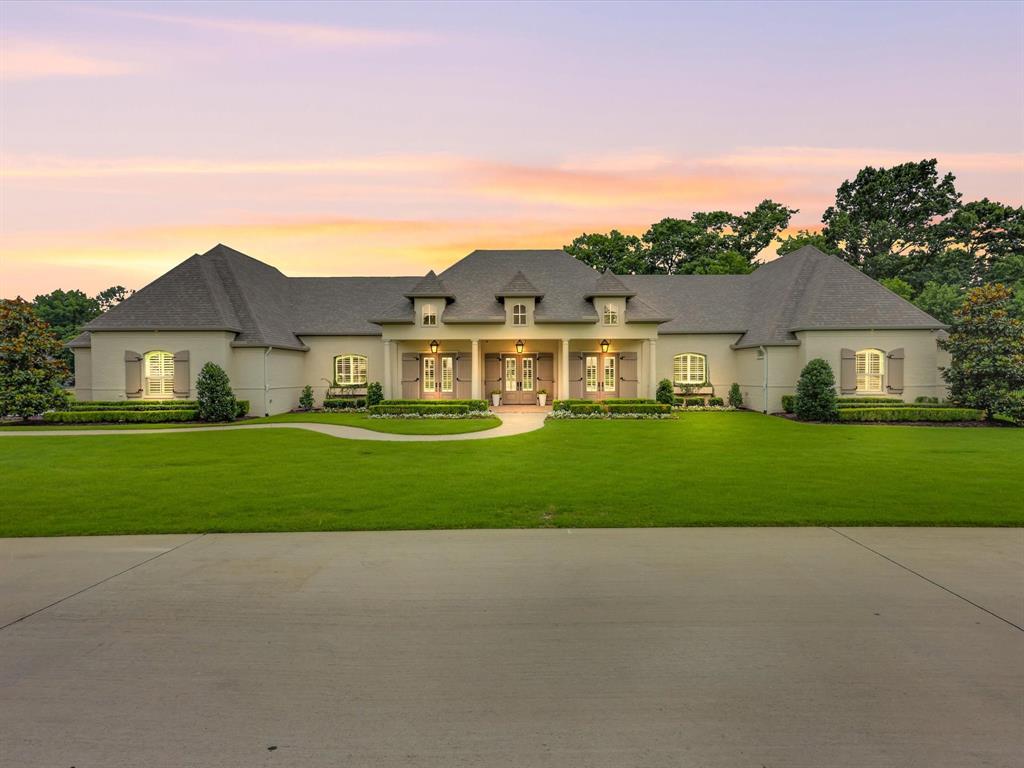 Tucked behind the gates of one of Celina’s most prestigious communities, Hidden Creeks Pointe, this one-of-a-kind estate welcomes you with timeless Southern charm and high-end sophistication. A grand brick-front porch with flickering gas lanterns sets the tone for the exquisite craftsmanship that lies beyond. Built by renowned custom builder Dave R. Williams, this masterpiece spans 1.75 acres and offers 5 beds, 7 baths and designer details at every turn. Oak floors, custom wood trim, and a tongue-and-groove Foyer ceiling elevate the elegance. The Chef’s Kitchen is adorned with exposed brick, wood beams, premium appliances, built-in fridge, two dishwashers, a full Scullery, massive pantry + Mudroom with brick flooring. A glass-enclosed Wine Room offers a dramatic focal point, visible from all living areas. The open-concept Great Room stuns with ceiling beams, custom built-ins, and panoramic sliders leading to the Outdoor Paradise. The Private Study features floor-to-ceiling shelving + custom millwork. Each bedroom offers an en-suite bath + spacious walk-in closet. The luxurious Primary Suite offers a vaulted ceiling adorned with beams, a spa-like bath with soaking tub, dual vanities, built-in coffee bar, boutique-style closet, and a private home gym with serene pool views. The oversized Laundry connects to the primary closet with plentiful cabinetry and sink for ultimate convenience. A fully equipped Home Theater includes a wet bar + beverage fridge. The Texas basement attic provides incredible storage and ease. Step outside to your Resort-Style Backyard equipped with motorized shades, overhead heaters, a gorgeous stone fireplace, covered dining space, manicured lawn, mature trees + total privacy with tranquil creek views. The heated and chilled Pool + Spa offer beautiful water features. Multiple lounge areas create the ultimate retreat. Impeccably designed for entertaining + everyday luxury, this home offers an elevated lifestyle in every detail; true Texas luxury.