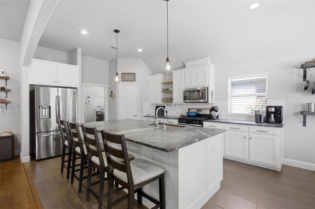 Tucked away on a quiet cul-de-sac in Live Oak Creek, this beautifully designed four-bedroom, two-bath home blends comfort, charm, and functionality with an inviting cottage-inspired feel. Built in 2015, the open-concept floorplan is filled with natural light and centered around an impressive oversized natural stone island that anchors the kitchen and creates the perfect gathering space for entertaining or everyday living. Stainless steel appliances, abundant cabinetry, and generous prep space make the kitchen as practical as it is beautiful while seamlessly flowing into the spacious living area with a cozy gas fireplace.

The dining area comfortably accommodates seating for eight, creating an ideal space for gatherings both large and small. Thoughtful details throughout the home, including built-in bookshelves, add warmth and character while maintaining a clean, modern aesthetic.

Privately situated apart from the secondary bedrooms, the expansive primary suite offers a true retreat with a resort-style bath featuring dual vanities, a soaking tub, standalone glass shower, and a large walk-in closet.

Step outside to the covered back patio and discover one of the home’s most peaceful features — a tranquil bubbling brook-style water feature complete with koi fish, creating a serene outdoor escape ideal for relaxing mornings or quiet evenings at home.

With a desirable split-bedroom layout, beautiful natural light, and inviting indoor-outdoor living spaces, this Live Oak Creek home offers the perfect balance of warmth, style, and everyday livability.
