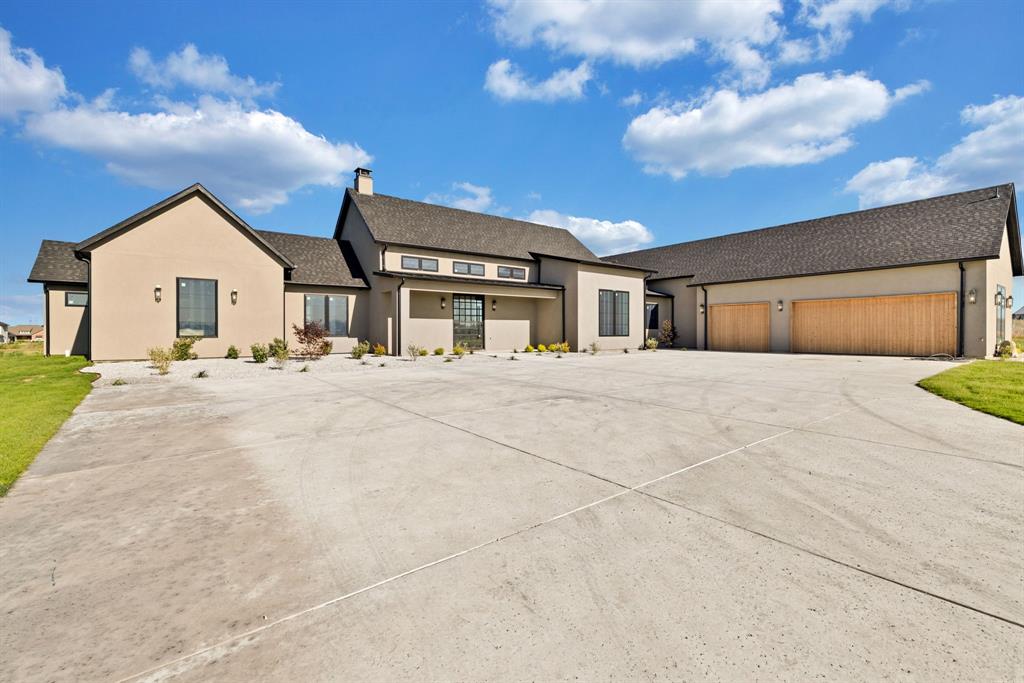 Experience elevated modern living in this stunning custom built stucco estate, offering approximately 5,251 square feet of meticulously crafted luxury on 2.5 acres in the heart of Krum. Designed with striking architectural detail and exceptional attention to craftsmanship, this newly constructed residence blends contemporary sophistication with everyday comfort. A dramatic pivot front door welcomes you into a light filled interior where soaring ceilings, expansive open concept living spaces, and a massive sliding glass wall create a seamless connection between indoor and outdoor living. Every detail has been thoughtfully curated, from the designer lighting and custom millwork to the premium cabinetry, fixtures, and architectural finishes found throughout. The home features five generously sized bedrooms, each with a private en-suite bath, along with a total of five full and one half bathrooms showcasing luxurious materials and designer selections. At the center of the home, the chef inspired kitchen impresses with custom cabinetry, statement stone surfaces, an oversized island, and a layout designed for both effortless entertaining and daily living. Upstairs, a dedicated theater room provides the ultimate movie-night experience, while a spacious bonus room with a full bath offers endless flexibility as a guest suite, game room, fitness studio, or private retreat. Set against the backdrop of wide open Texas skies, this exceptional property delivers the perfect balance of privacy, space, and modern luxury. Rarely does a home combine this level of design, craftsmanship, and acreage in such a desirable setting. A true showcase of contemporary architecture and custom construction crafted to impress and designed to be lived in. Welcome to your forever home.