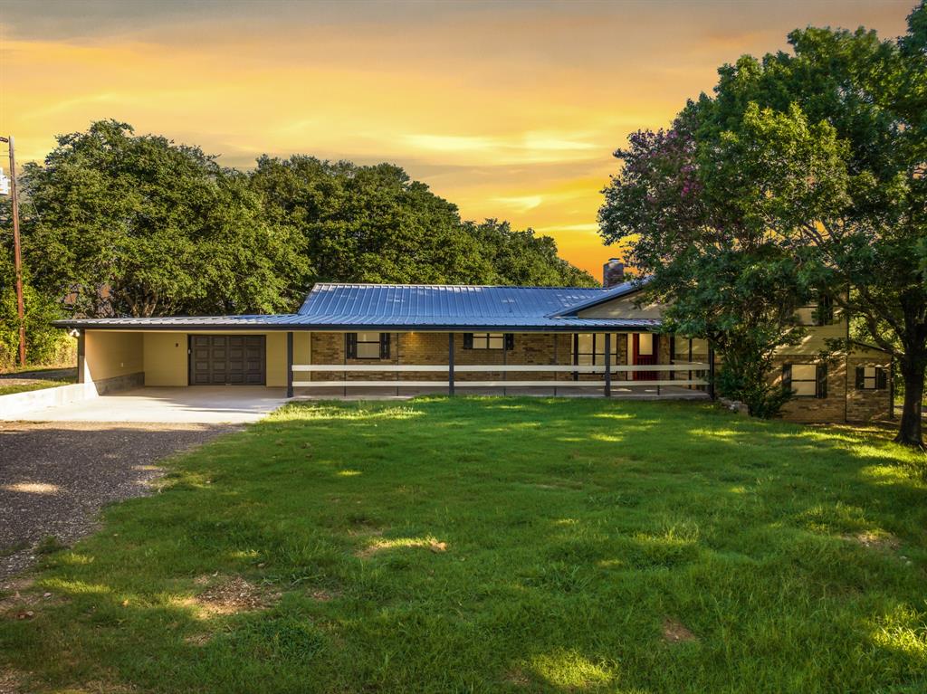 Country Charmer Remodel is just waiting for you to call it home!! This gem sits on 22 acres. House sits far off the road giving a very peaceful atmosphere and unlimited privacy!! Home features 4 bedrooms and 4 full baths and could easily be a 5 bedroom if needed with 2 laundry areas. There is a 2nd living with bedroom and bath downstairs would be a perfect set up for a mother in law suite. Relax by the fireplace or drink your Texas tea enjoying the breeze on your beautiful extra large front porch. Beautiful wooded area with partial 12 acres ag exemption! Watch the deer play right from your back porch. This home also has a storm shelter, nice workshop, implement shed, and individual pens perfect for your goats or chickens. This home has foam insulation in attic, dual AC units, attached 1 car garage that is extra large  +carport and a screened in hot tub in the back.  Don't miss out on this amazing property! Listing agent also the seller