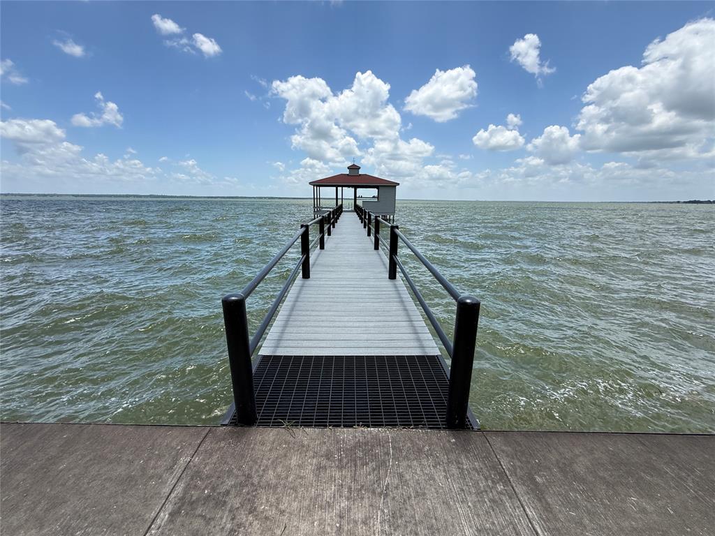 Build your dream waterfront home on Richland Chambers Lake from a lot that's already loaded with valuable improvements. Located inside the gated Arrowhead subdivision, this 0.79-acre waterfront homesite offers mature pecan trees, breathtaking open water views, and exceptional infrastructure already in place.

A standout feature is the custom 900-square-foot boathouse built by David Kyle Builders, complete with water and electric service, cedar siding, metal ceiling, Trex decking, double railings along the 100-foot walkway, a 10' x 24' boat slip with electric lift, aluminum pontoon cradle, swim stairs, and a boathouse closet prewired for an irrigation pump.

The shoreline is improved with a retaining wall and a 4-foot-wide, 125-foot concrete sidewalk featuring an expanded lakeside sitting area perfect for relaxing and enjoying the view. Additional site improvements include a culvert, roughed-in driveway, installed water and electric meters, and completed soil core samples by Eyncon Engineering.

Arrowhead property owners enjoy gated access plus exclusive use of a private community boat ramp and dock. With major improvements already completed and spectacular open water views waiting outside your future back door, this is an outstanding opportunity to create the lakefront lifestyle you've been dreaming about.