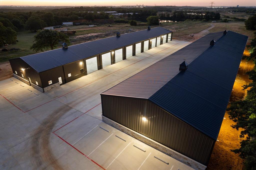 Priced to sell, this amazing turnkey property is perfect for the owner user or seasoned investor.  KEY POINTS ARE NO CITY TAXES LOCATED IN THE KENNEDALE ETJ.  Approximately 14 acres located in Fort Worth, only 4 miles south of I-20 and US 287.  Close proximity to I-35, FM 1187, and Hwy 360.  Brand New Rock Column Fence and Hardscape Landscape gives this property the ultimate curb appeal.  Brand New 2025 Construction of 2-50'x240' free span buildings being 12,000 sq ft for a total of 24,000 sq ft.  16' wall height with 23' center.  Each building can be divided into 4 suites if needed. Plenty of room for Motorhomes, Boats, RV's, Charter Buses, Equipment, the uses are endless.  A total of 22 power 14'x14' overhead doors that are fully insulated and can be controlled by an app with multiple users or from each door controller.  These doors are extremely quiet when opening and closing. Site Plan has room for an additional 6-12,000 sq ft buildings. Great for additional income producing buildings as an owner user or investor. Front concrete circle drive with additional concrete parking and yard or equipment parking.  Each building is fully lighted inside and out.  The outside lights are on photocells to conserve energy and add increased security. 1,500 sq ft office with a total of 6 offices prewired for data ports.  Fiber Optic Now Available.  New Central HVAC in office.  Upgrade Office Doors with security locks.  Do you need yard space, this property offers plenty of yard space for any need.  The back of the property has approximately a 4 acre pond with incredible park like views.  The North end of the pond has a cliff with hiking trails and perfect for park benches to watch the seasonal ducks and geese or just to watch the fish below waiting to be fed. The pond is fully stocked with Large Mouth Bass, Catfish, and Perch.  There are 2 floating fish feeders on timers in the pond.  This ONE-OF-A-KIND PROPERTY has so much to offer with endless possibilities and uses.