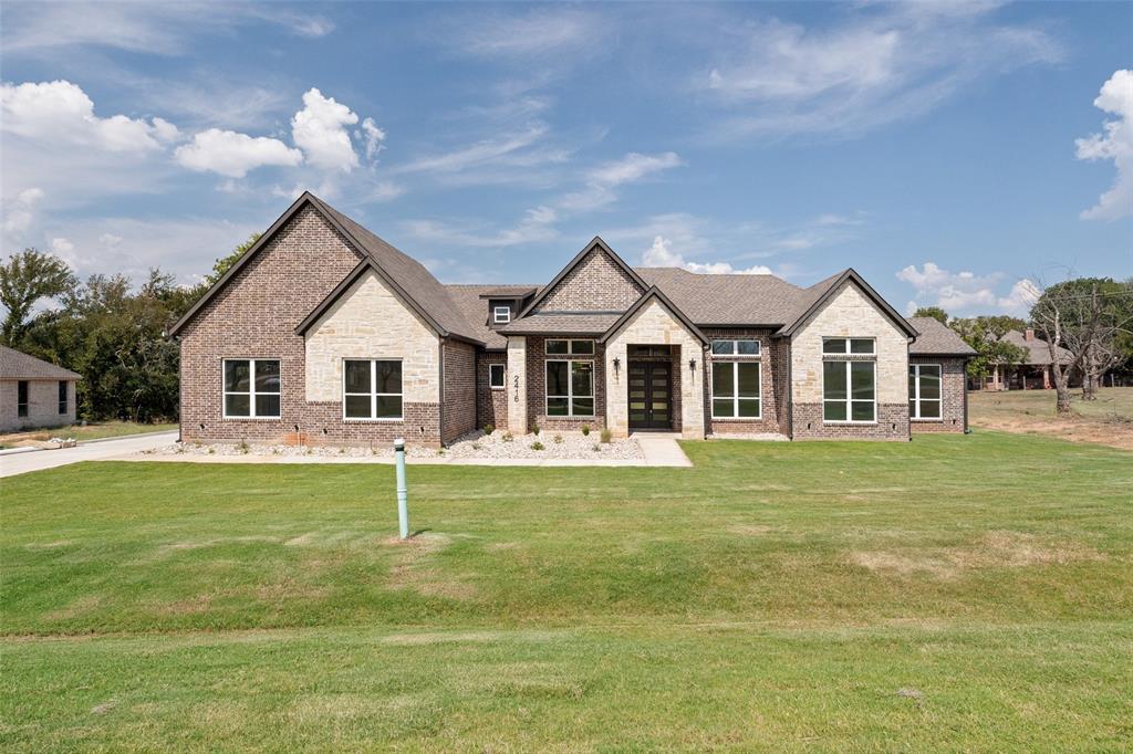 Discover a beautifully crafted new build in the gated, amenity-rich community of Pecan Plantation where modern design, thoughtful detail, and everyday luxury meet. Step through the front double doors and into a home that immediately impresses with 14-foot ceilings, rich engineered wood floors, and upscale finishes that flow throughout. The living room is anchored by a stunning built-in fireplace framed with custom cabinetry and shelving, creating a warm yet sophisticated focal point. The open layout flows seamlessly into a chef-inspired kitchen complete with quartz countertops, a large island designed for gathering, a six-burner gas cooktop, and stainless steel KitchenAid appliances. A designated dining room and private office are conveniently located off the entryway, offering both functionality and elevated style. Your primary ensuite is a true spa retreat, featuring dual sinks, a free-standing soaking tub, an expansive walk-in shower, and a custom-built closet with direct access to the laundry room—an everyday luxury you’ll love. A split floor plan ensures comfort and privacy for all. Across the home, a mother-in-law suite offers its own attached bathroom with a walk-in shower and a spacious closet. Two additional bedrooms, each with generous closet space, share a beautifully finished full hall bath. Off the 3-car garage, you'll find a mud bench, a spacious storage closet, and half bath for guests. Entertain your new neighbors outback on the 18x16 covered patio. Built with efficiency and longevity in mind, this home also features fully encapsulated spray foam insulation, Low-E windows, two tankless water heaters, and propane gas. Set within one of Texas' most sought-after communities, you’ll enjoy access to golf, dining, parks, and countless amenities just beyond your doorstep. Experience the unmatched lifestyle of Pecan Plantation—schedule your private tour today.