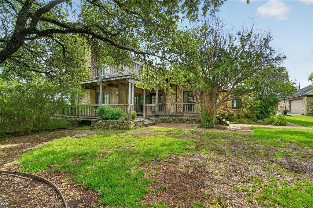 Rare opportunity to own a private retreat on nearly a full acre (0.9531 acres) just minutes from Downtown Fort Worth. Tucked away in a quiet cul-de-sac and surrounded by a stone wall enclosure, this unique property offers the perfect blend of privacy, space, and convenience with easy access to Loop 820, schools, shopping, dining, and entertainment.

The main home features 3 bedrooms and 3.5 bathrooms, including a secluded upstairs primary suite complete with its own fireplace and access to an expansive wraparound deck with stunning views of the Fort Worth skyline. The secondary bedrooms are located on the main level, providing a functional layout for family and guests.

Designed for both comfort and entertaining, the home offers two spacious living areas, each featuring its own fireplace, for a total of three fireplaces throughout the property. Large windows and elevated outdoor spaces create a seamless connection to the surrounding landscape and city views.

One of the property’s most desirable features is the detached guest quarters, which includes a private bedroom and full bathroom. Ideal for multigenerational living, guests, a home office, studio, or potential income-producing opportunities, this separate space provides exceptional flexibility.

Properties offering nearly an acre of land, skyline views, detached living quarters, multiple fireplaces, and close proximity to Downtown Fort Worth are few and far between. Don’t miss your chance to own this truly one-of-a-kind property.